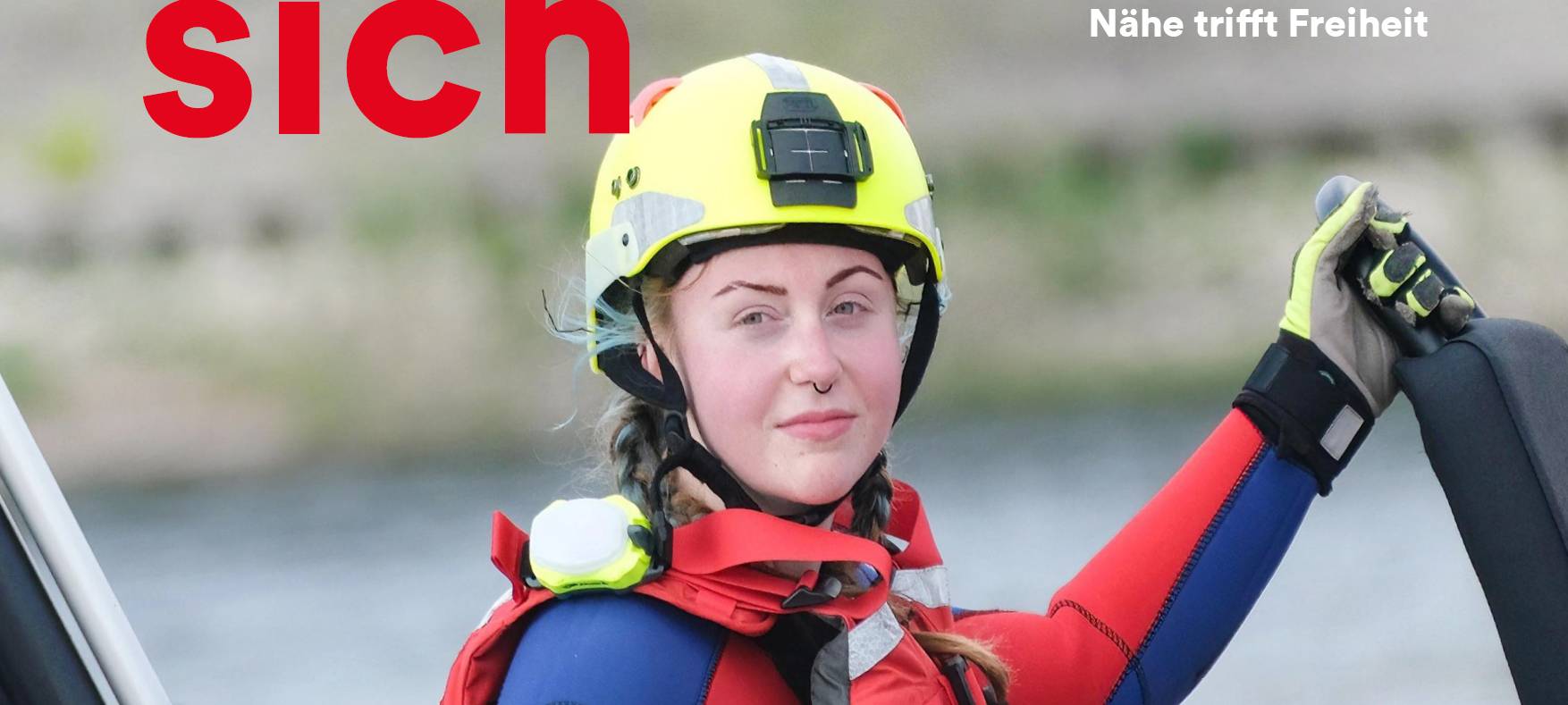 Junge Frau steht in DLRG-Bekleidung im Wasser. Drüber steht der Slogan "Düsseldorf engagiert sich".