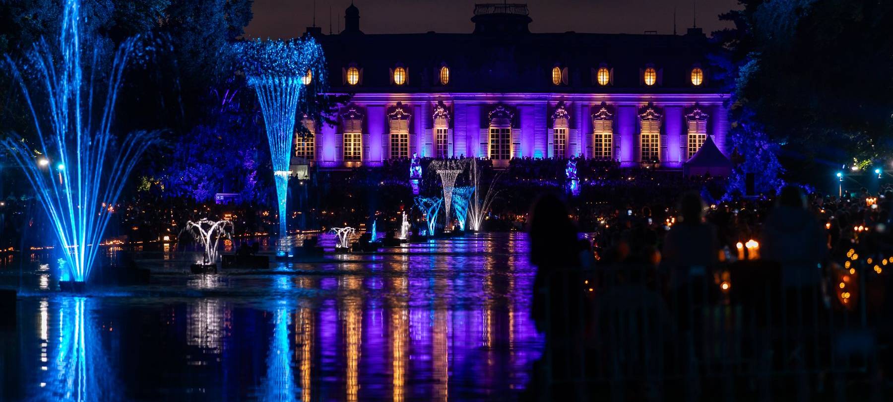 Der Spiegelweiher leuchetet beim Benrather Lichterfest in blau und lila.