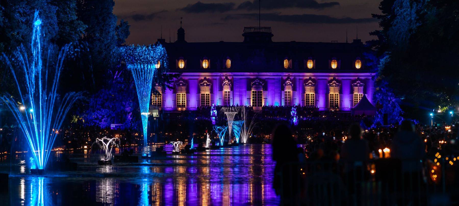 Der Spiegelweiher leuchetet beim Benrather Lichterfest in blau und lila.