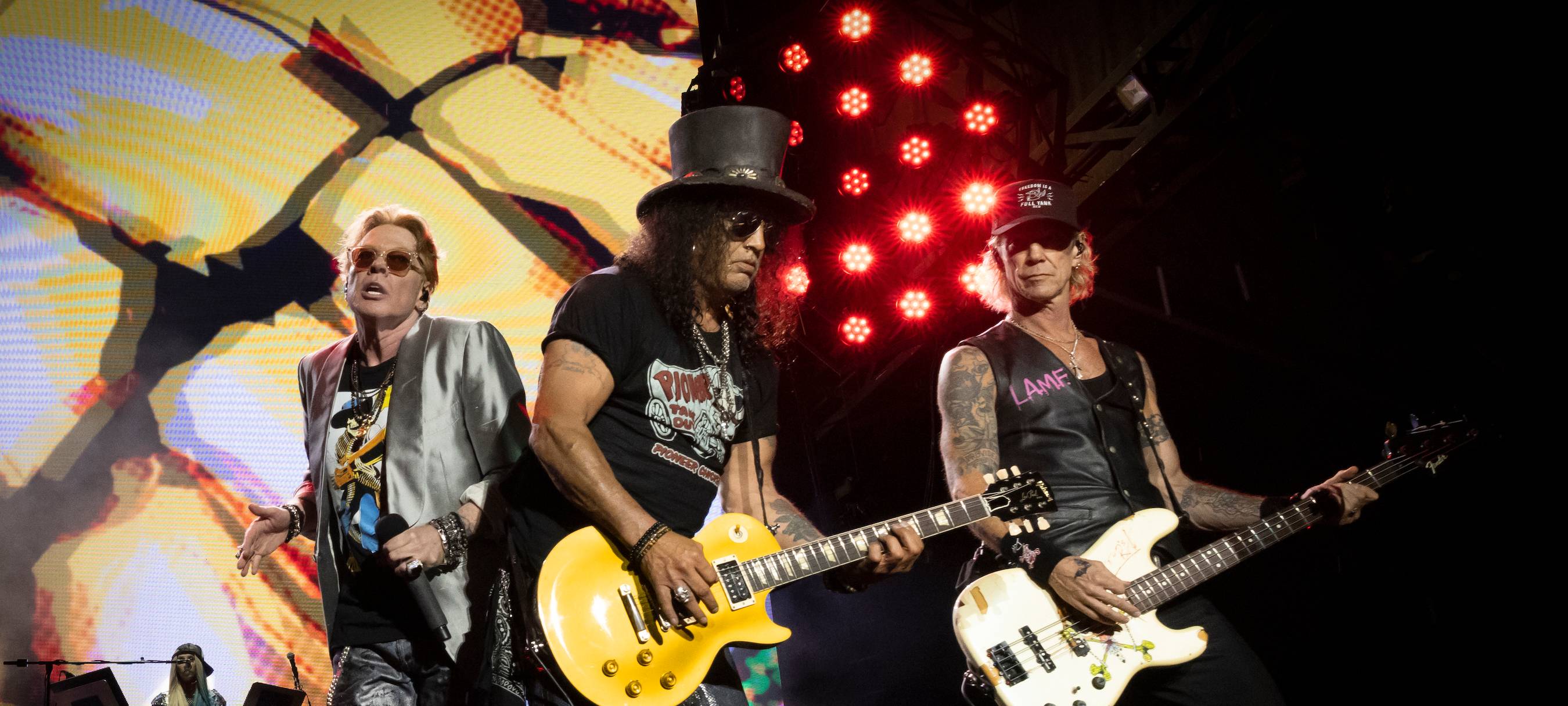 Die Band GUNS N’ ROSES auf einer Bühne. Im Mittelpunkt steht Gittarist Slash.