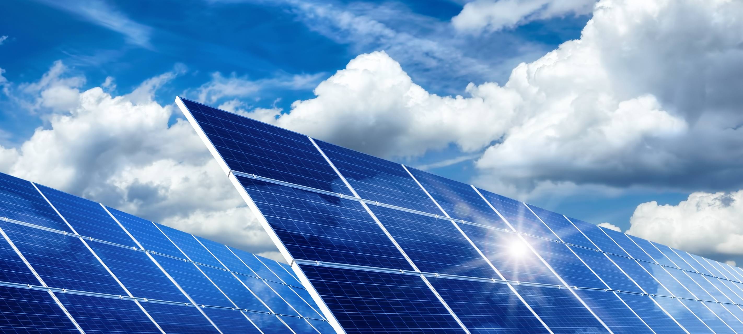 Solarkollektoren, Sonne und Wolken. Der Himmel ist blau.