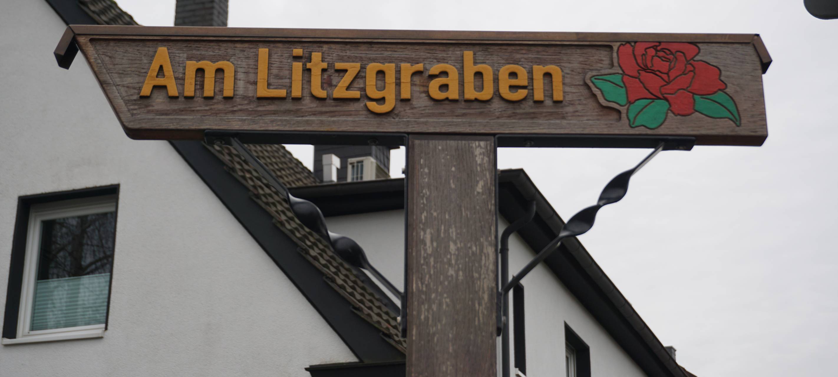 Eines der aus Holz geschnitzten Straßenschilder in Angermund