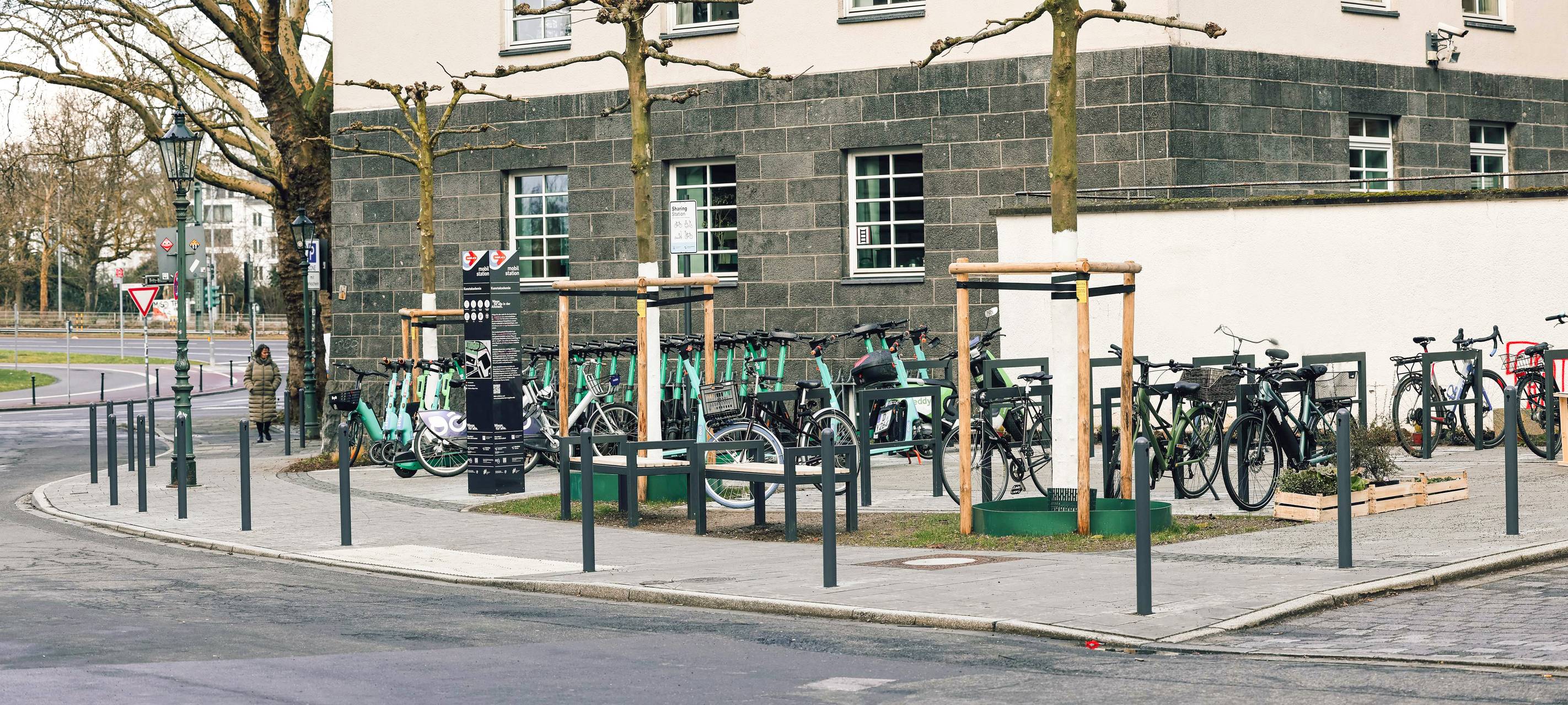 Die neu errichtete Mobilitätsstation direkt gegenüber dem Eingang der Kunstakademie mit Bäumen und Sitzgelegenheiten.
