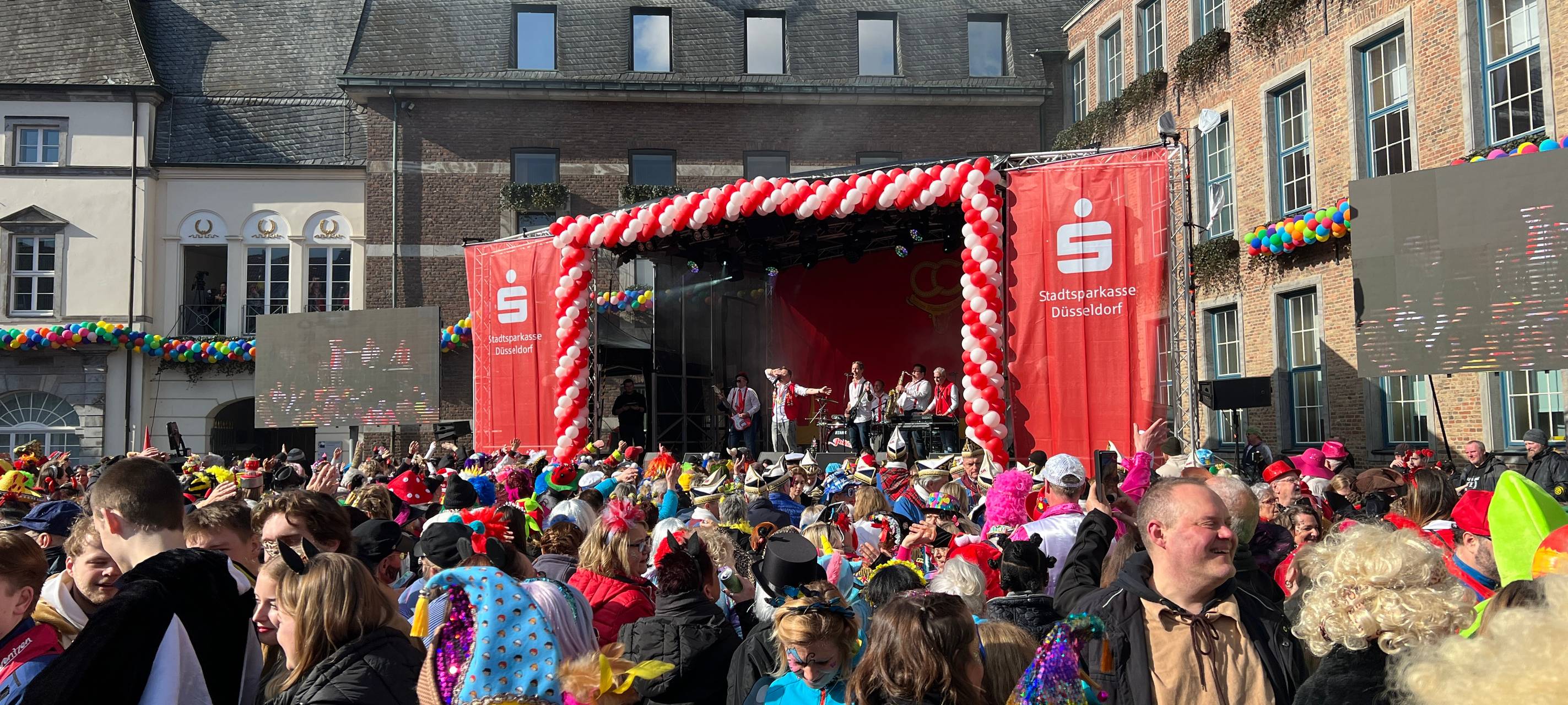 Viele verkleidete Menschen die zusammen Altweiber auf dem Rathausplatz feiern