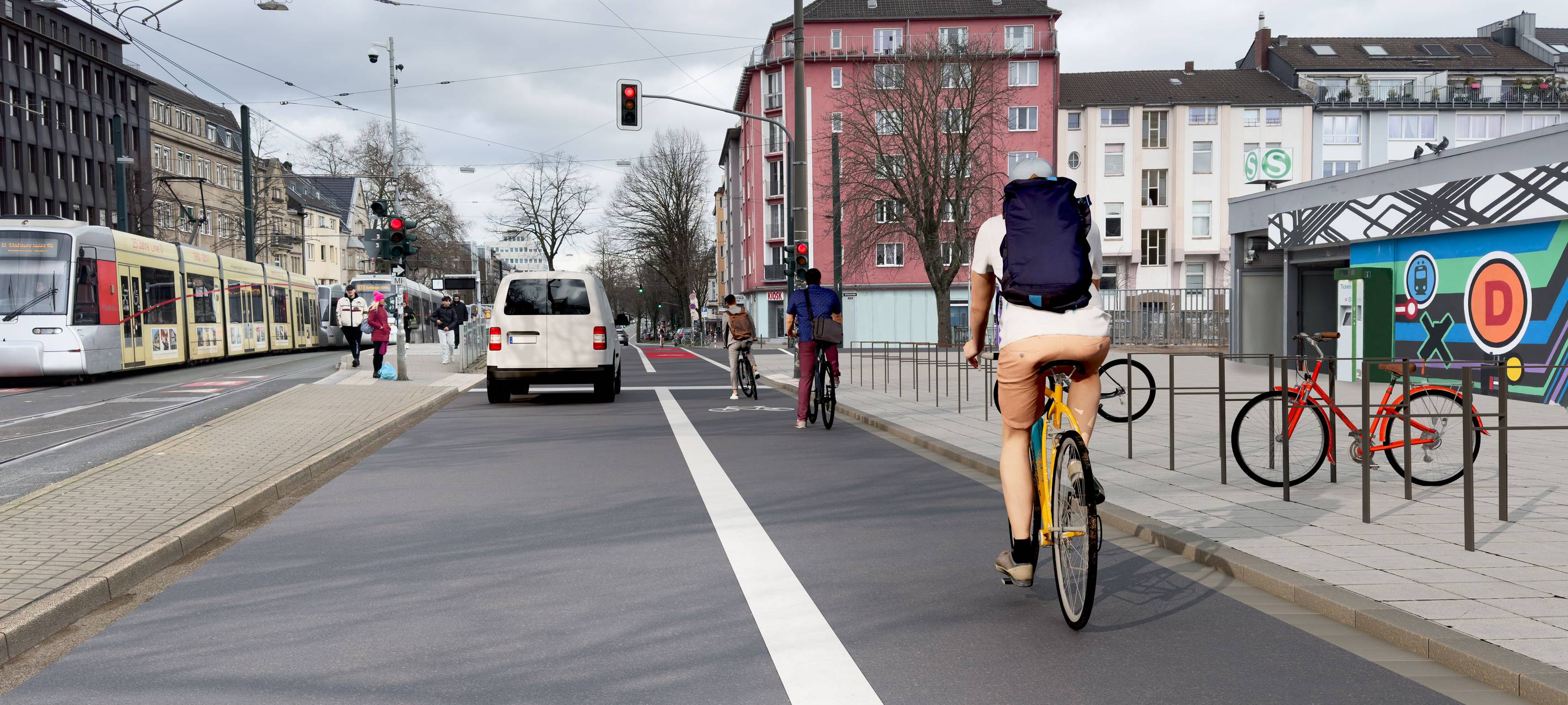 Über die Radleitroute am Wehrhahn fahren auf der rechten Spur Räder in Richtung Grafenberger Allee. Auf der linken Spur fahren Autos. Daneben befinden sich die Gleise für die Bahnen der Wehrhahnlinie.