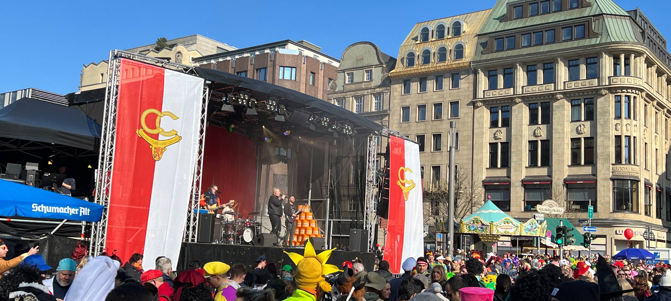 Viele Jecken feiern gemeinsam vor der großen Bühne beim Kö-Treiben