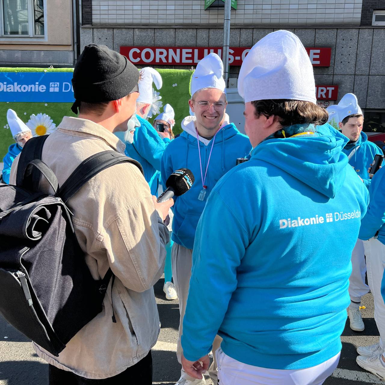 Unser Reporter Hugo fänft mit Mikrofon die Stimmung auf dem Rosenmontagsumzug ein.