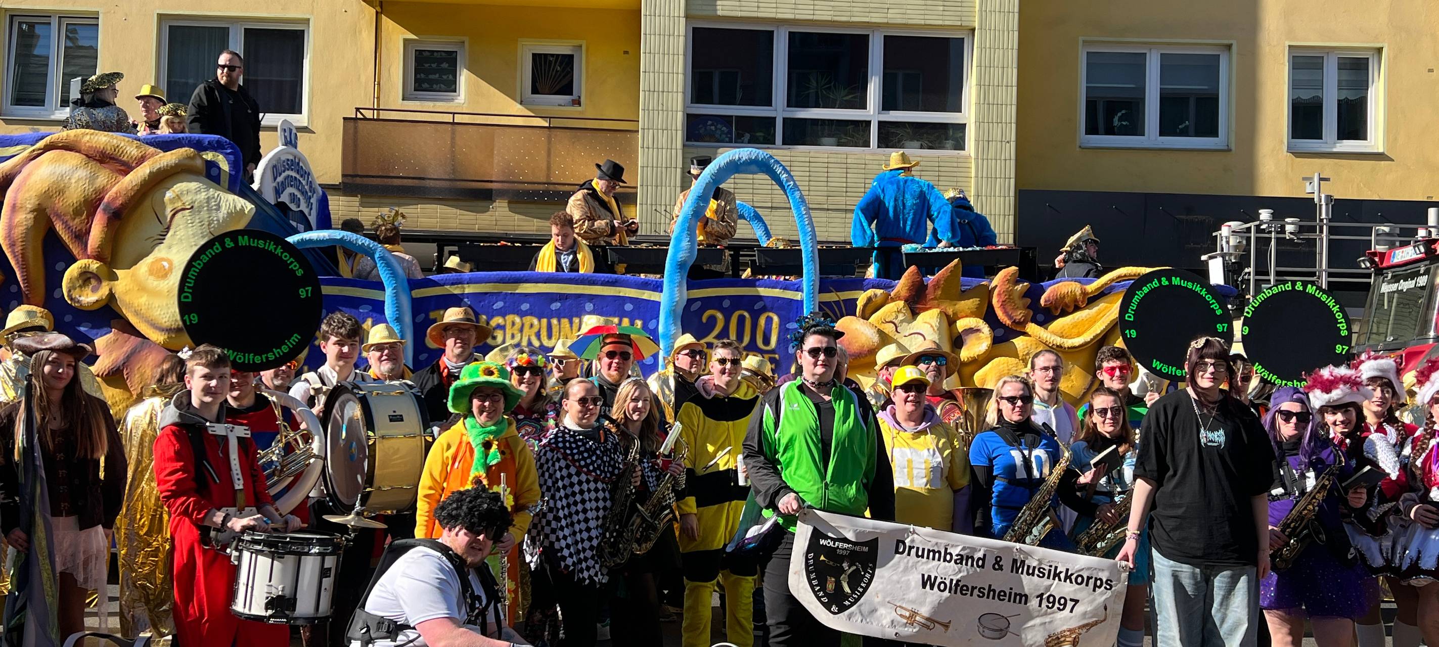 Eine Gruppe von verkleideten Jecken vor ihrem Wagen kurz vor dem Start des Rosenmontagsumzuges.