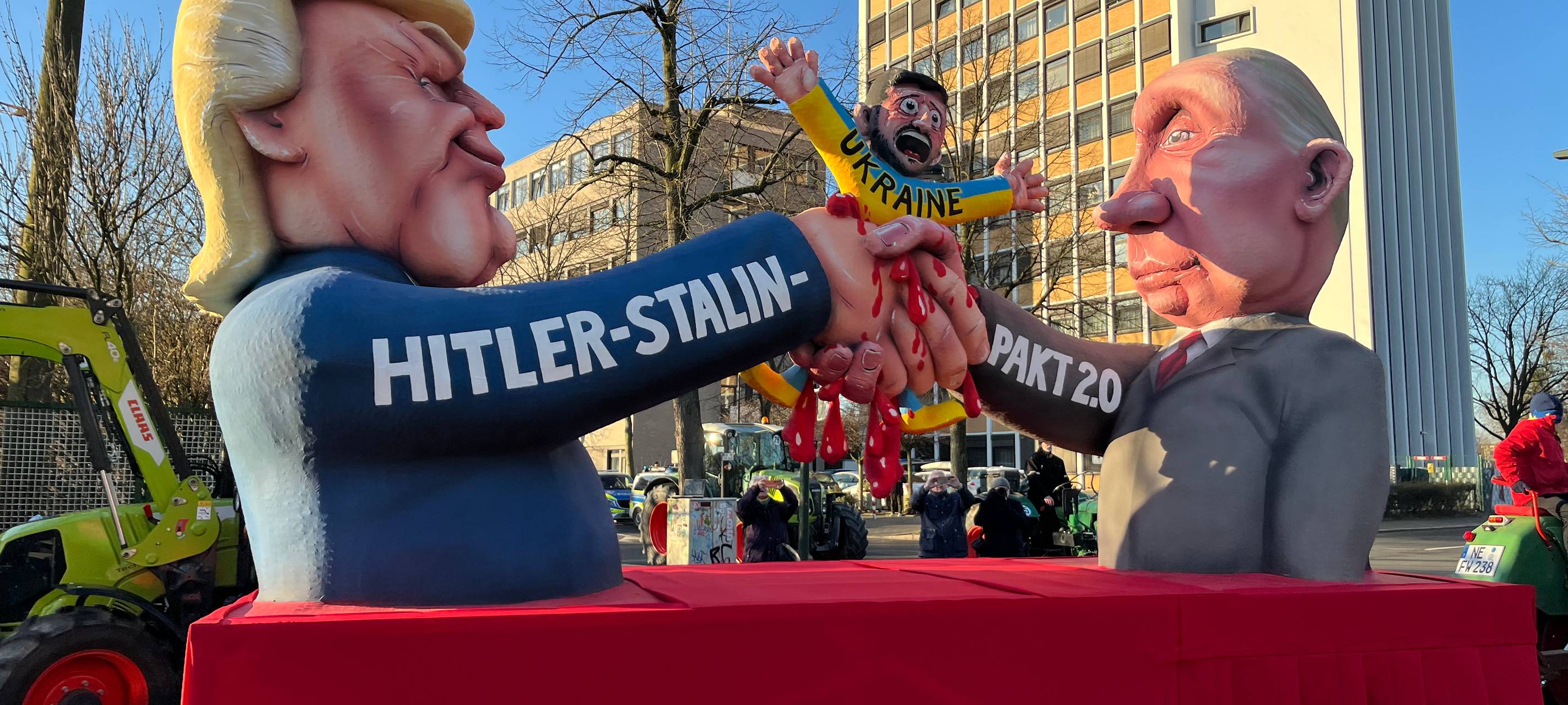 Mottowagen beim Karneval: Putin und Trump, die sich zum Hitler-Stalin-Pakt 2.0 die Handreichen und dabei die Ukraine zerquetschen.