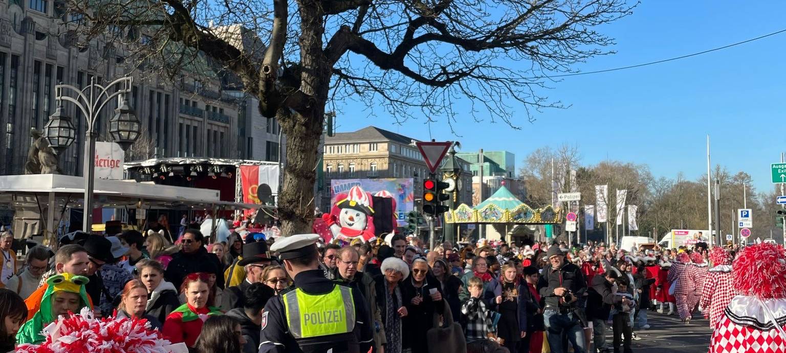 Ein Blick auf die vielen verkleideten Jecken aus Sicht einer Fußgruppe während des Rosenmontagsumzuges.