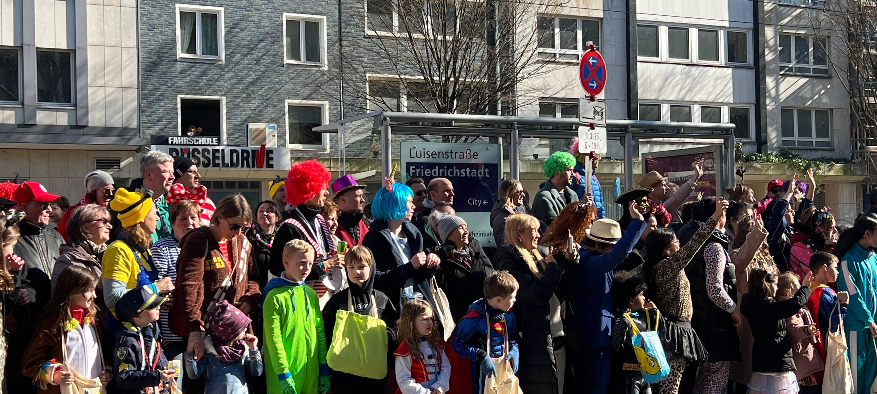 Viele verkleidete Jecken warten gemeinsam friedlich auf den Rosenmontagsumzug.