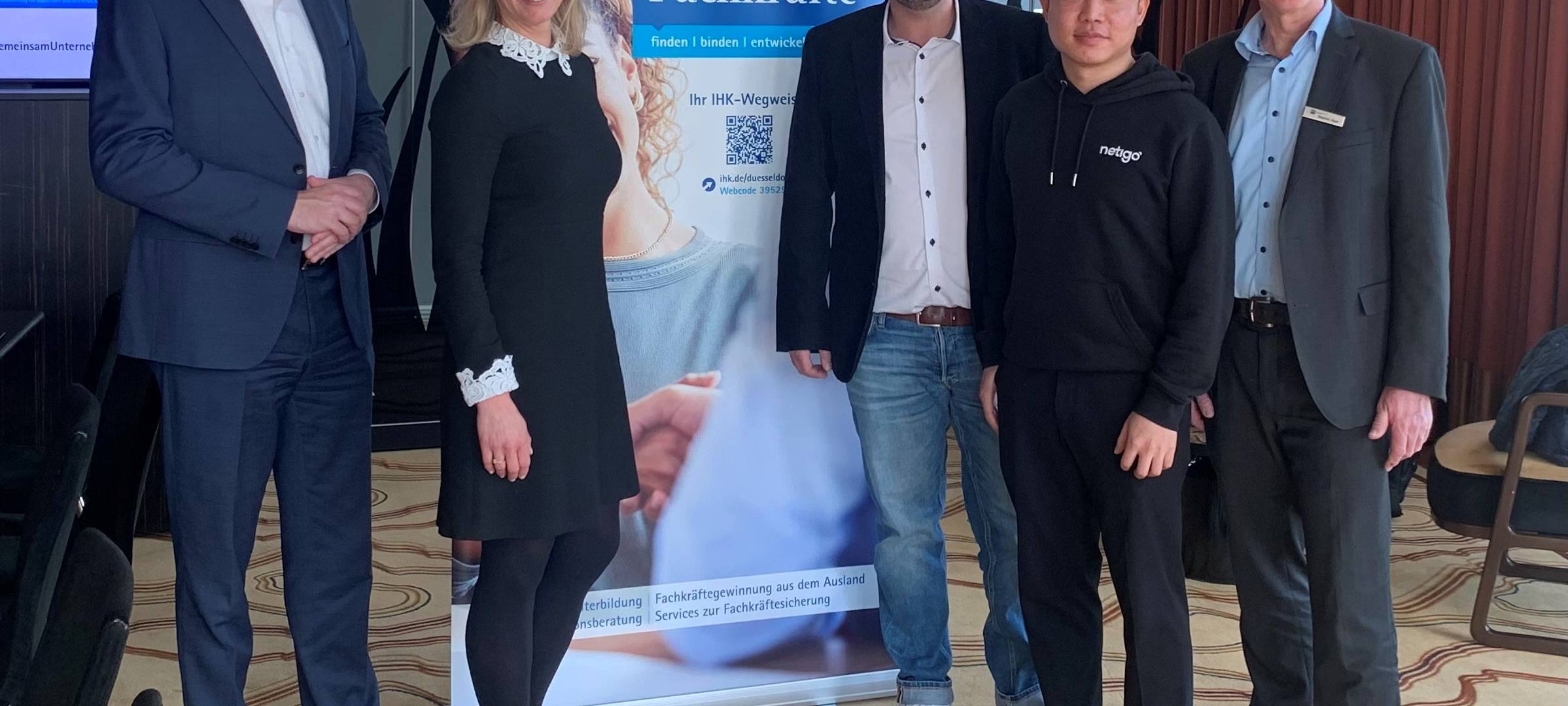 Zu sehen sind Vertreterinnen und Vertreter der IHK Düsseldorf, Hyatt Regency Hotel und Netigo GmbH. Sie stehen vor einem Schild zum Thema "Fachkräfte".