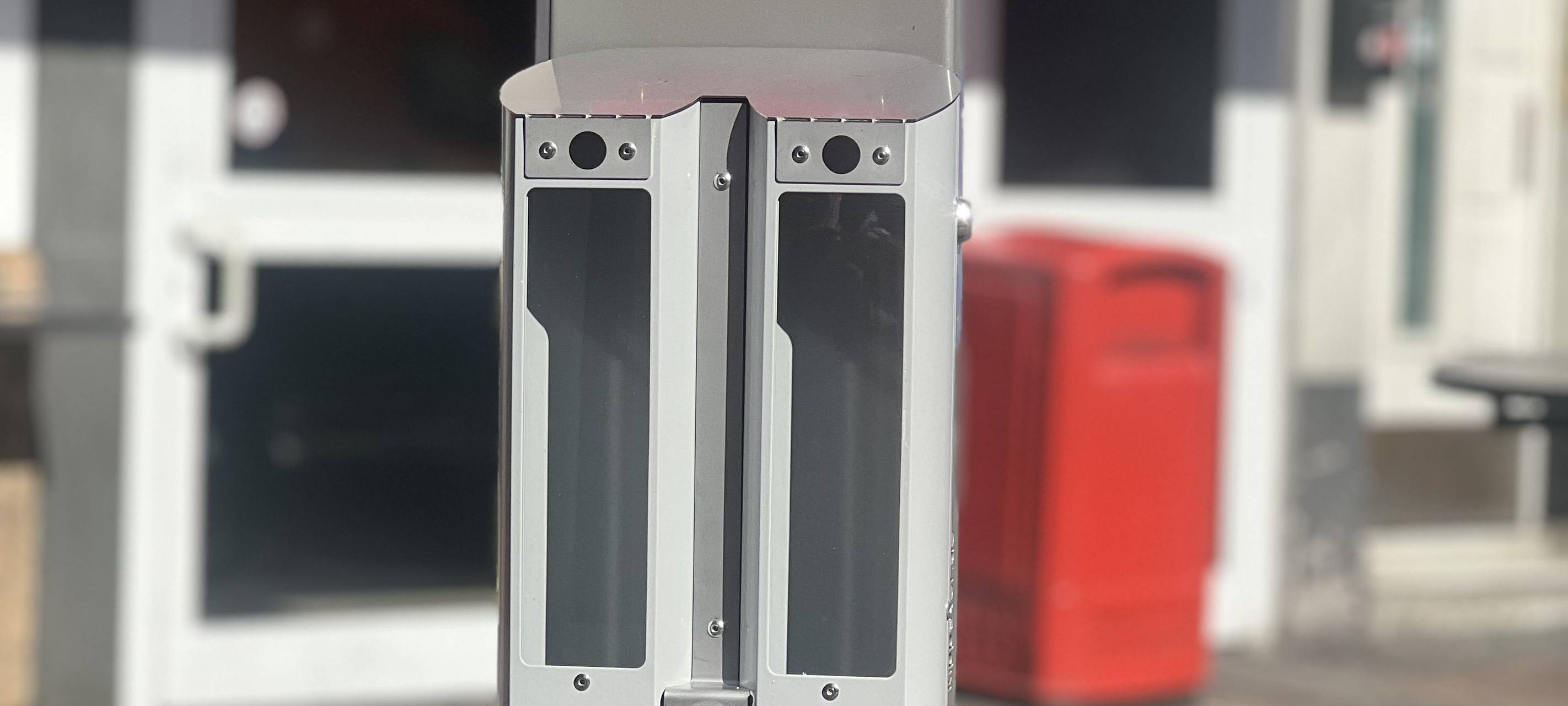 An einem Pfahl in der Altstadt hängen nebeneinander zwei Aschenbecher. Über einem steht auf einem roten Schild "Pils", über dem anderen "Alt".