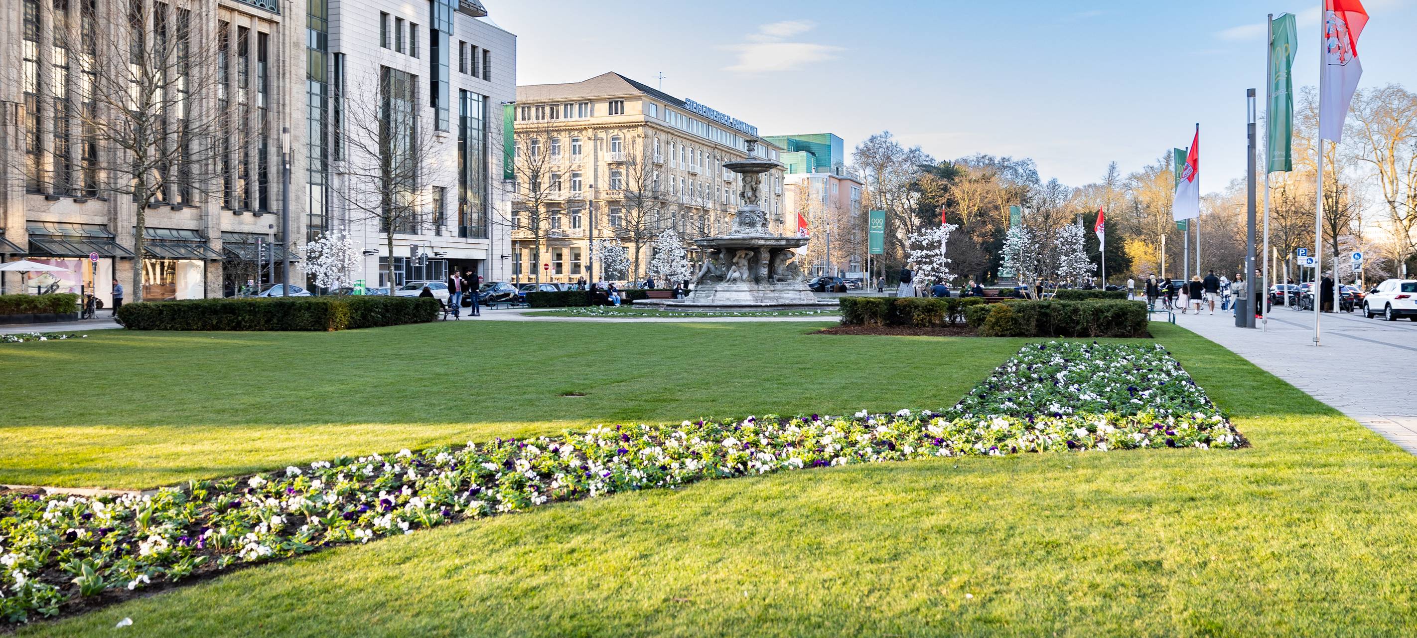 Blumenbepflanzung an der KÖ. Laufender Brunnen in der Mitte