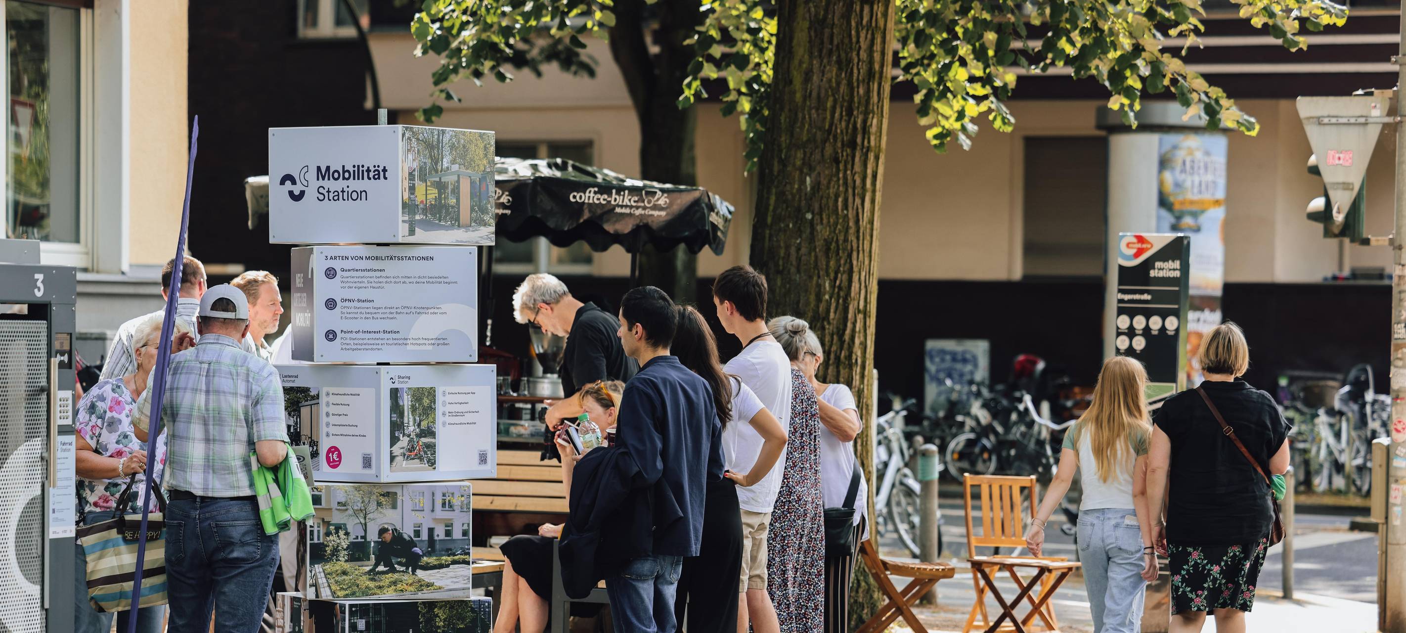 Eine Mobilitätsstation in Düsseldorf mit Menschen davor