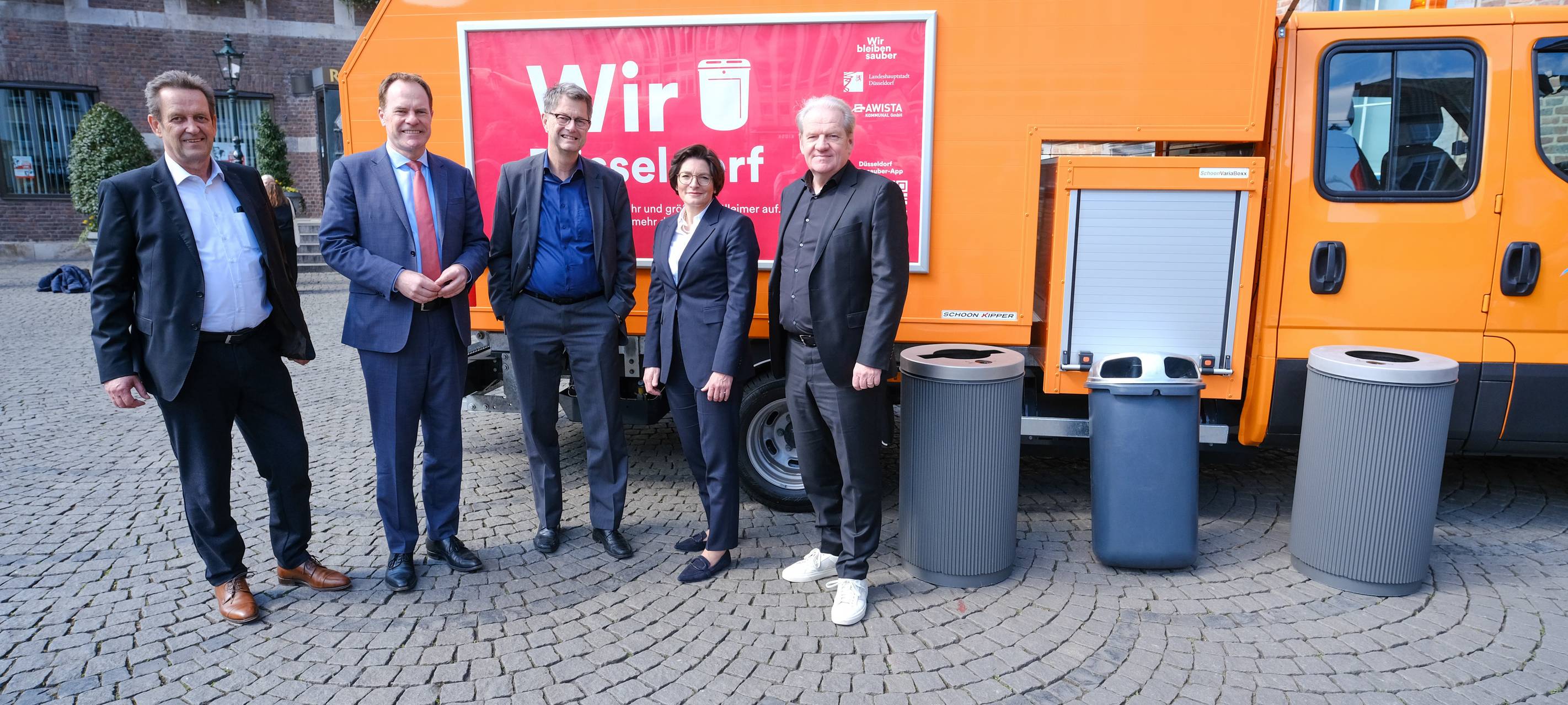 OB Keller und Mitarbeitende von Stadt und AWISTA präsentieren die aktuelle Sauberkeitsoffensive. Sie stehen neben verschiedenen Mülltonnen vor einem AWISTA-Fahrzeug. Dieses ist auf dem Marktplatz vor dem Rathaus in der Altstadt abgestellt.