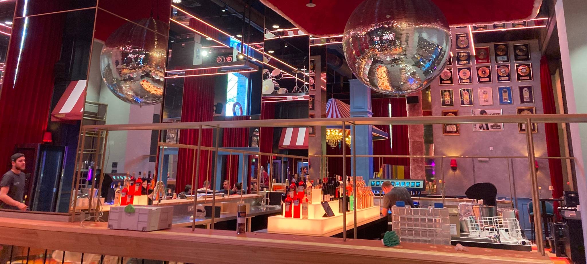 Eine Theke in einer Bar, oben steht "Schlager", von der Decke hängt eine große Discokugel.