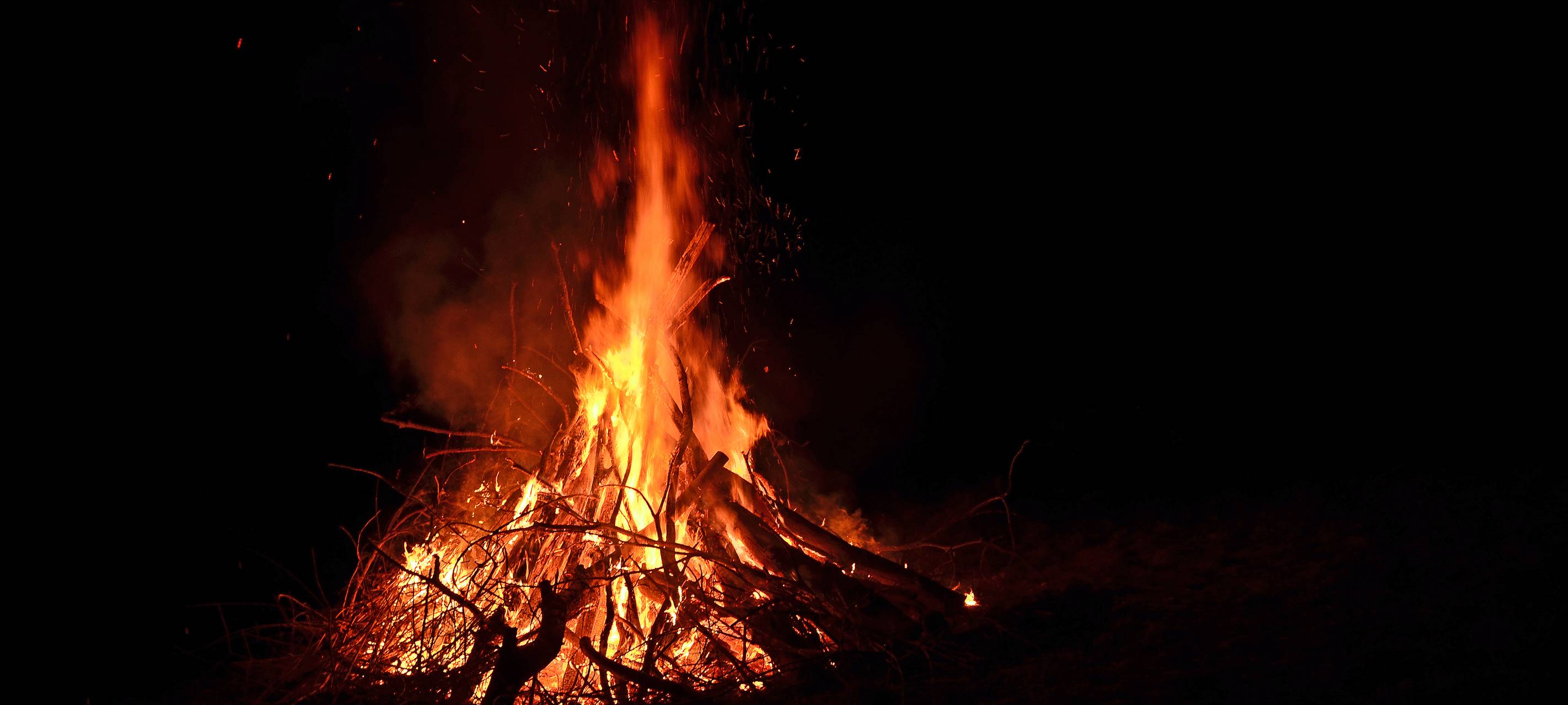Ein brennendes Osterfeuer in der Dunkelheit.
