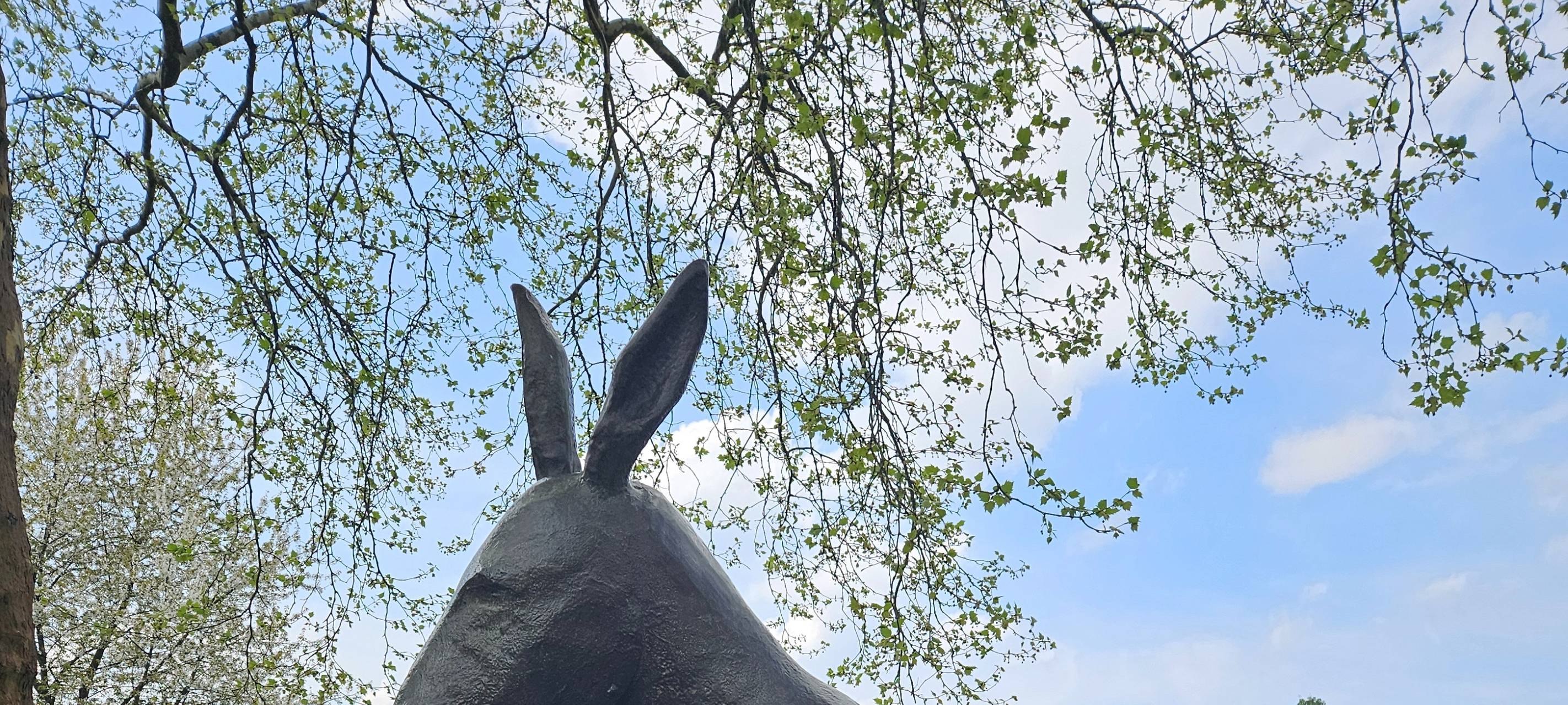 Statue "Springender Esel" mit Wiese im Hintergrund