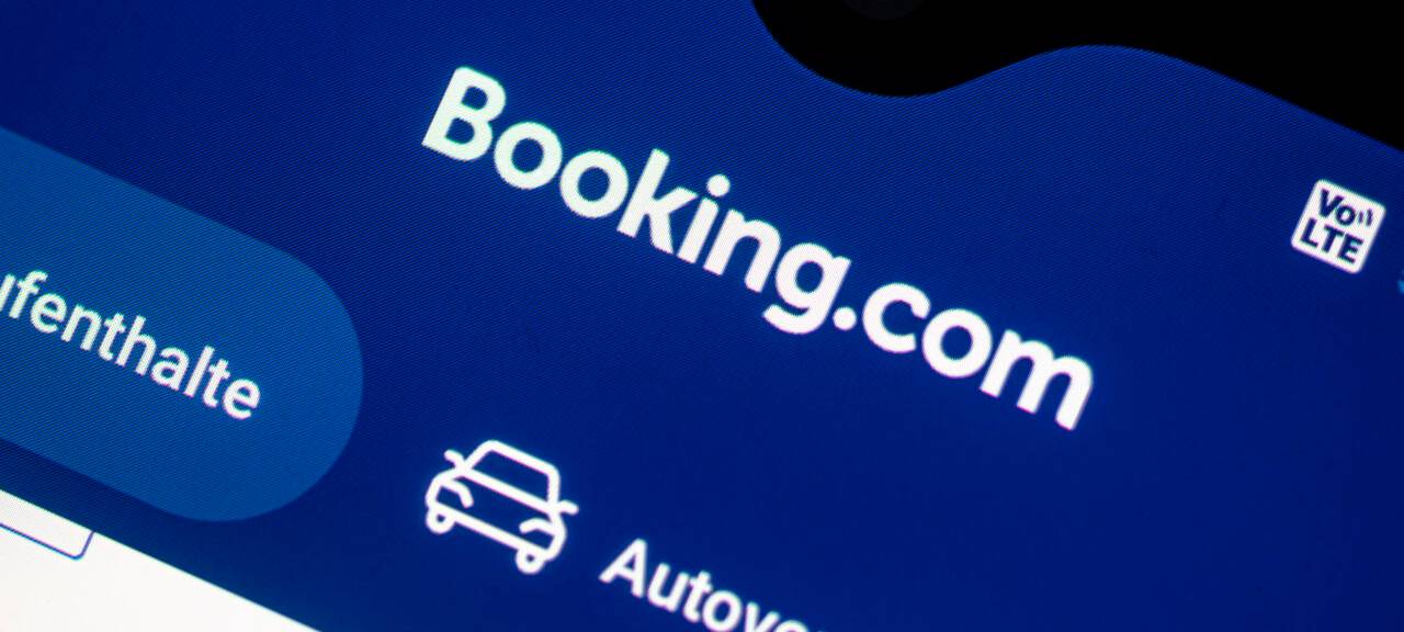 Auf einem Smartphone ist die App des Reiseportals Booking.com zu sehen.