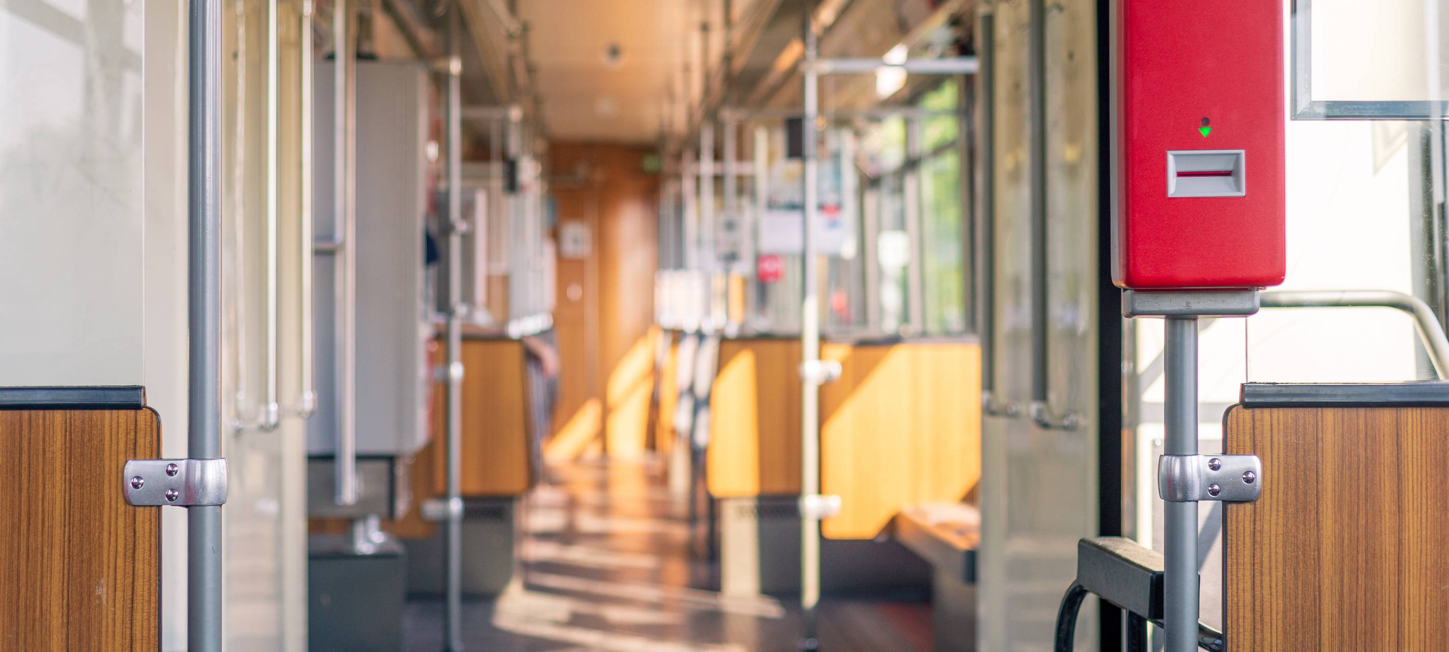Innenansicht einer U-Bahn der Rheinbahn. Die U-Bahn ist sonnendurchflutet. Die Sitze der Bahn sind leer.