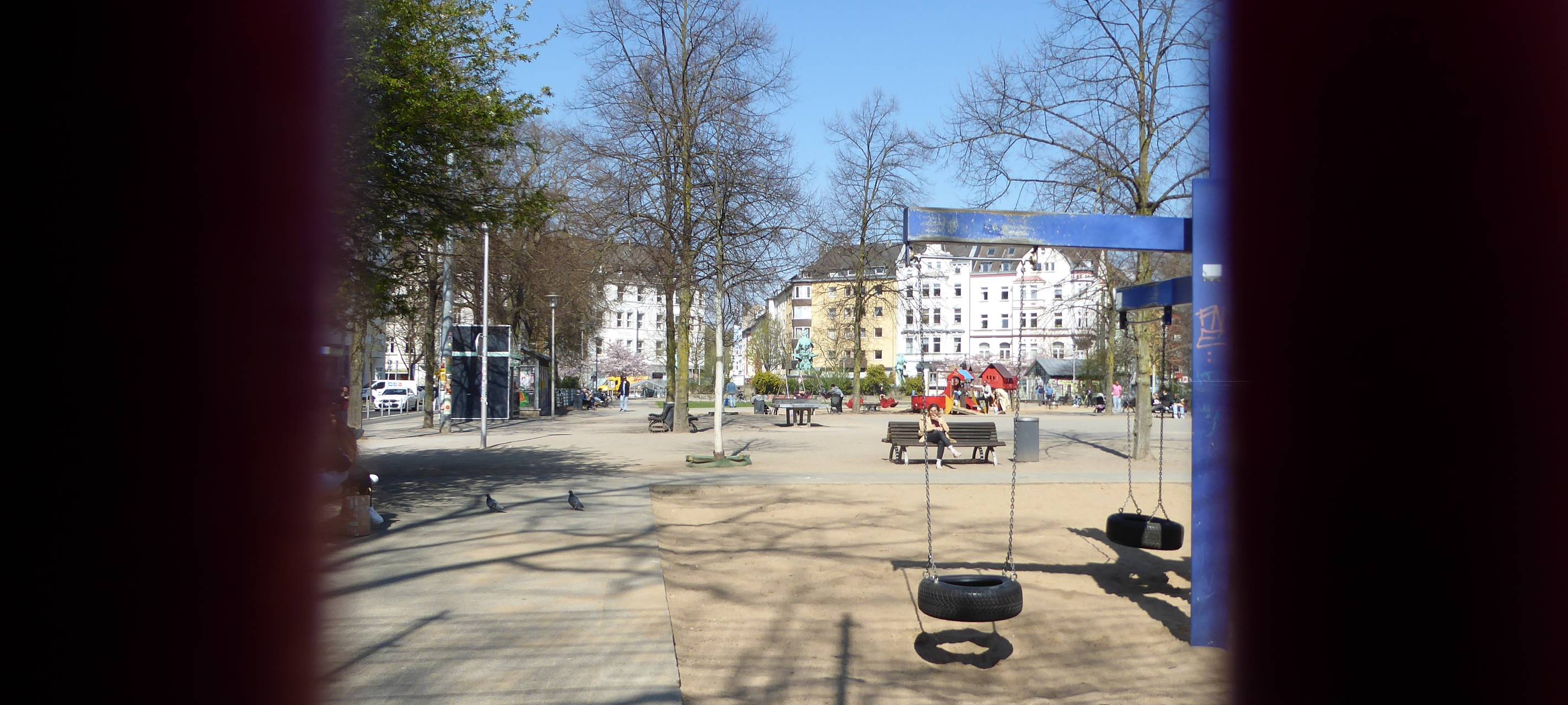 Blick auf den Spielplatz am Fürstenplatz, im Vordergrund Spielgeräte, hinten Häuser