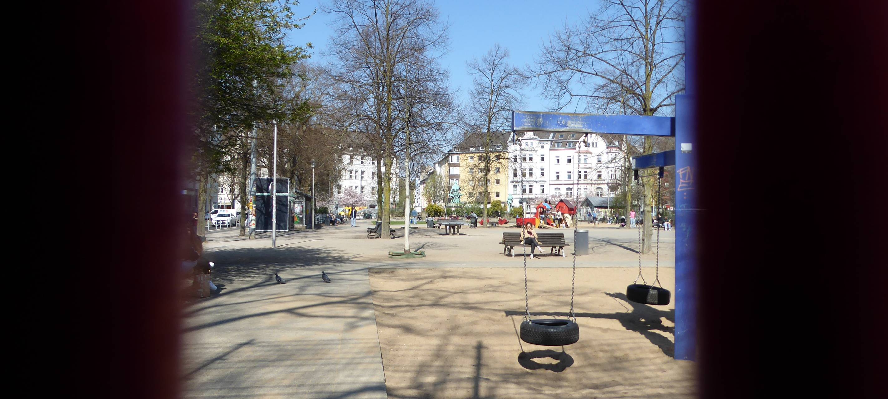 Blick auf den Spielplatz am Fürstenplatz, im Vordergrund Spielgeräte, hinten Häuser