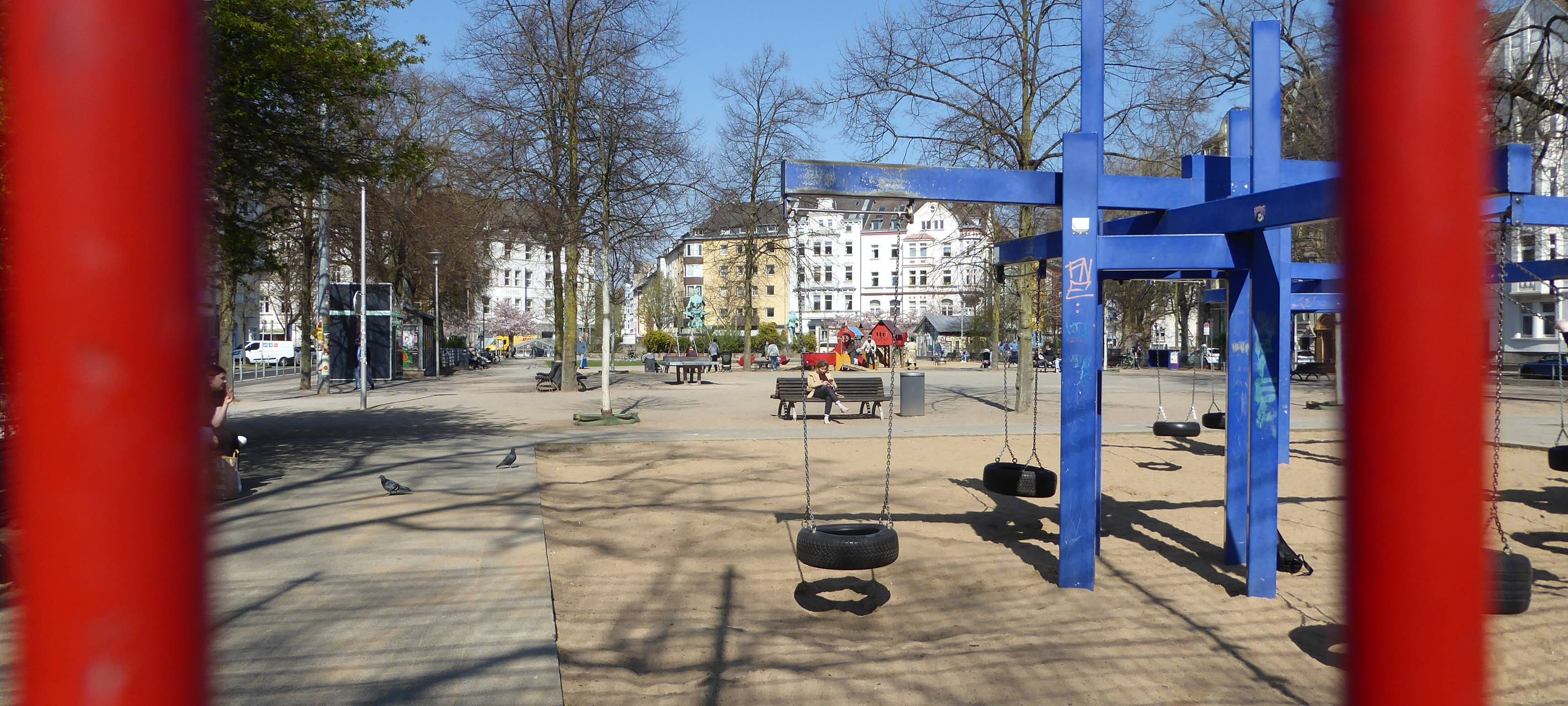 Blick auf den Spielplatz am Fürstenplatz, im Vordergrund Spielgeräte, hinten Häuser