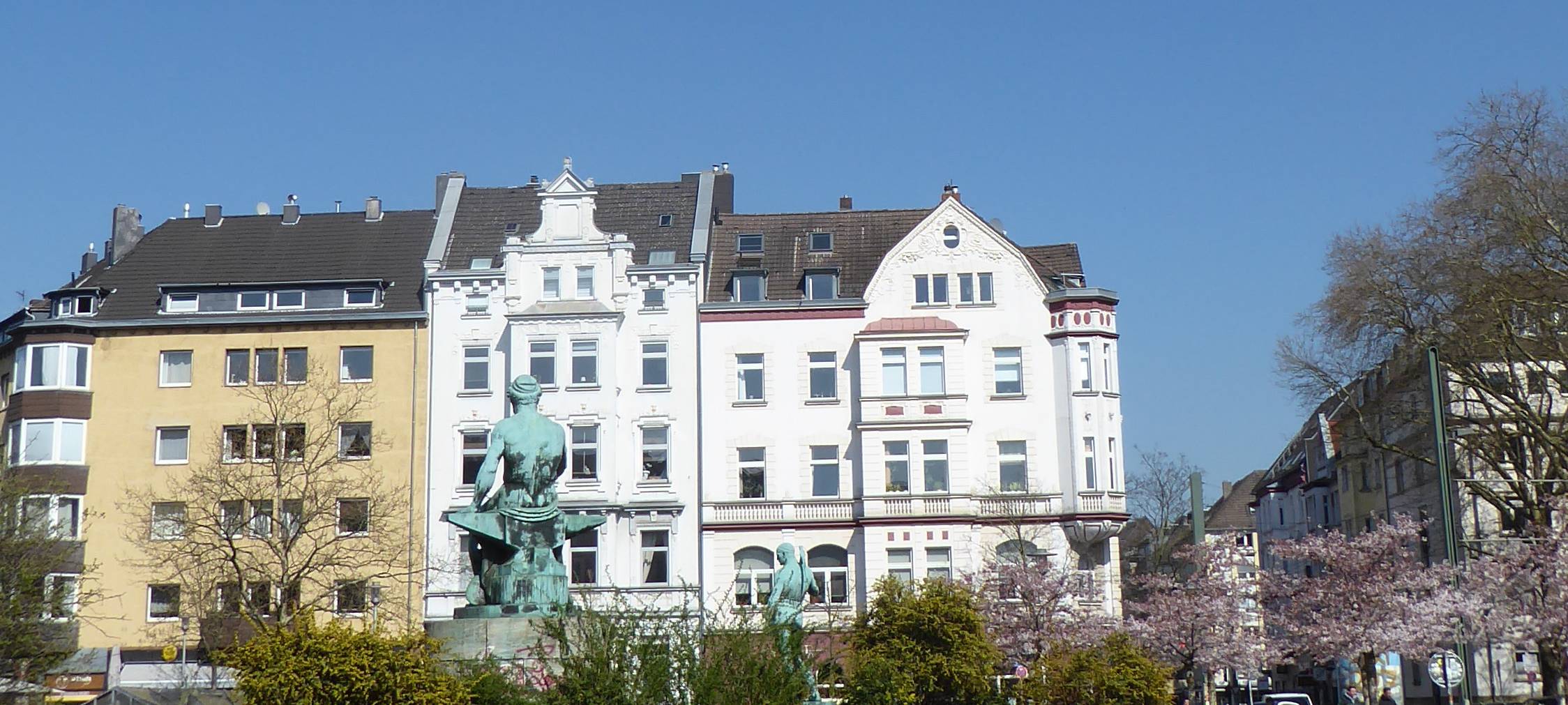 Der Fürstenplatz. Im Vordergrund Rasen, im Hintergrund schöne alte Häuser, dazwischen ein Brunnen.