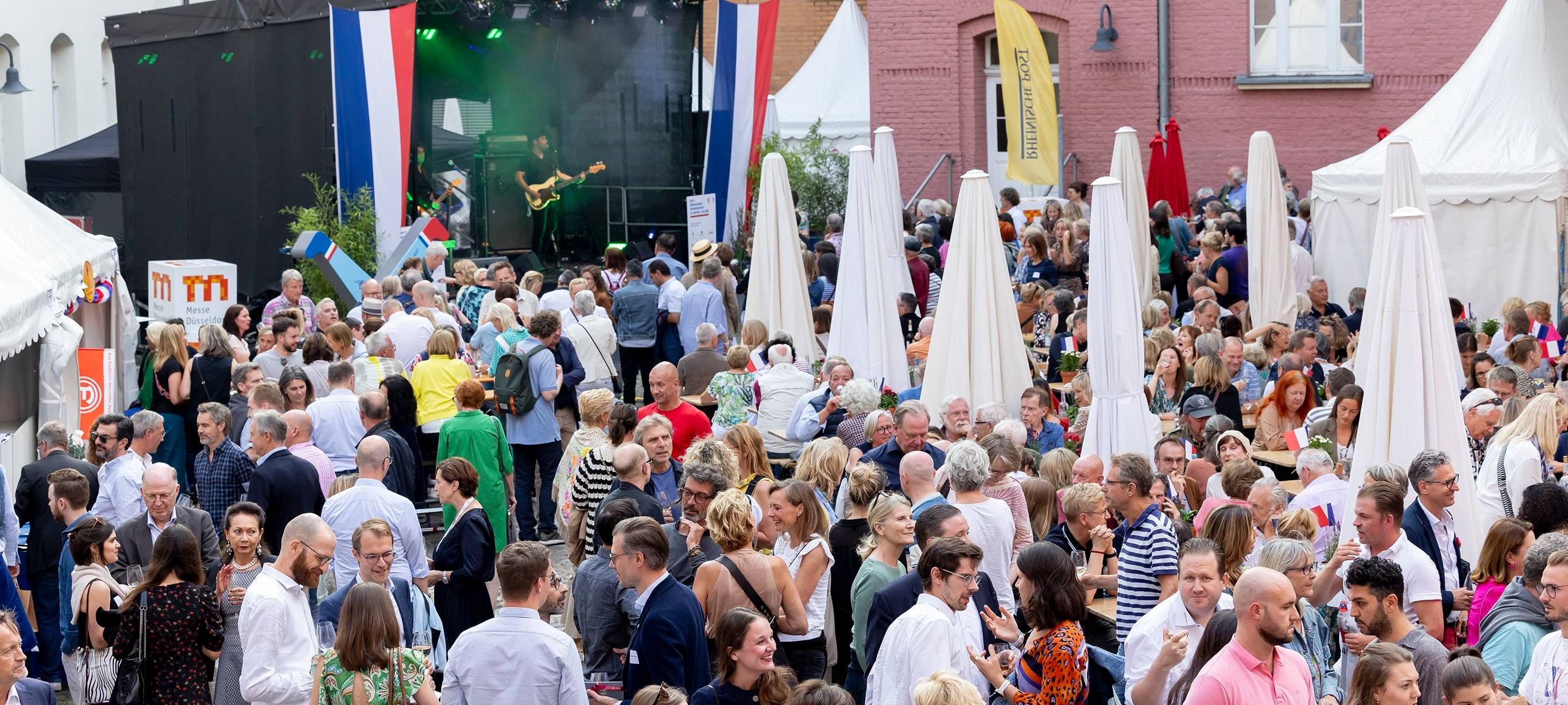 Eindrücke vom Frankreichfest. Im Rathaus-Innenhof feiern Menschen vor einer Bühne.