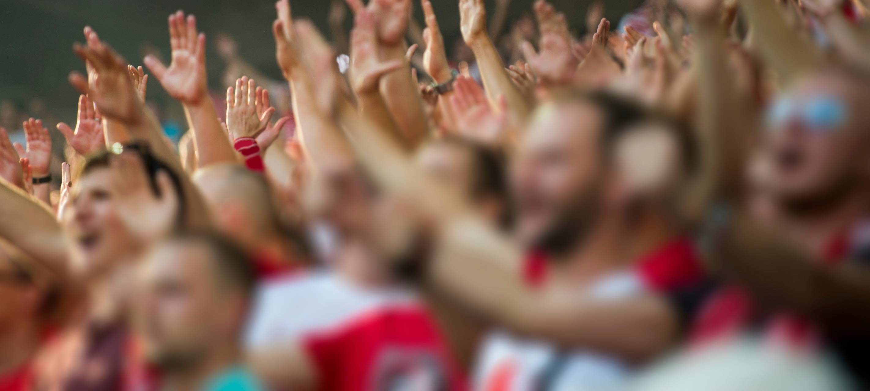 Fußballfans klatschen auf der Tribüne des Stadions.