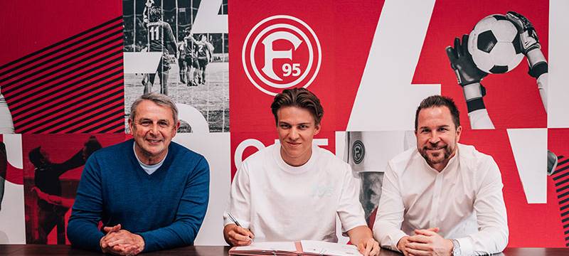 Klaus Allofs, Julian Hettwer und Christian Weber sitzen an einem Tisch bei der Vorstellung von Julian Hettwer.