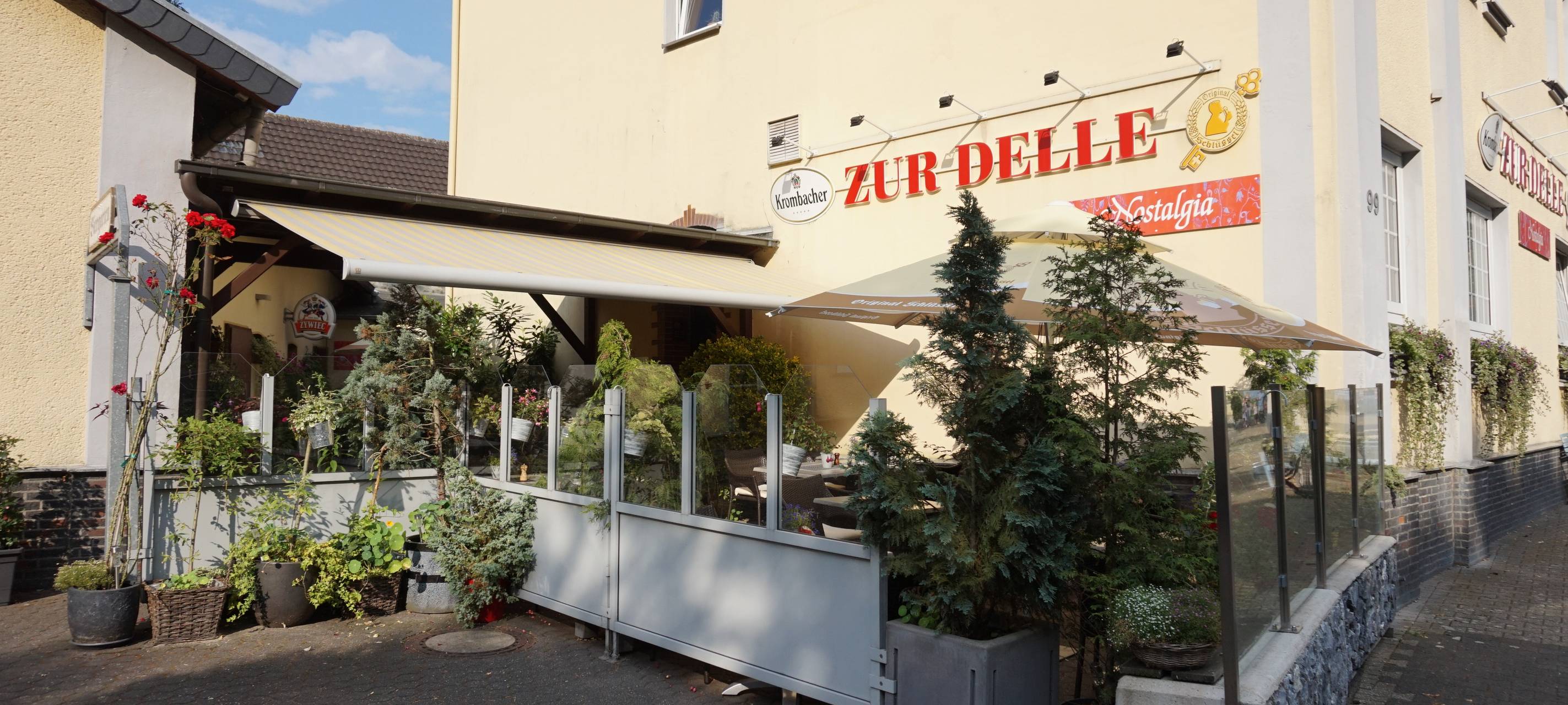 Restaurant Nostalgia Zur Delle mit Terrasse und Gebäude.