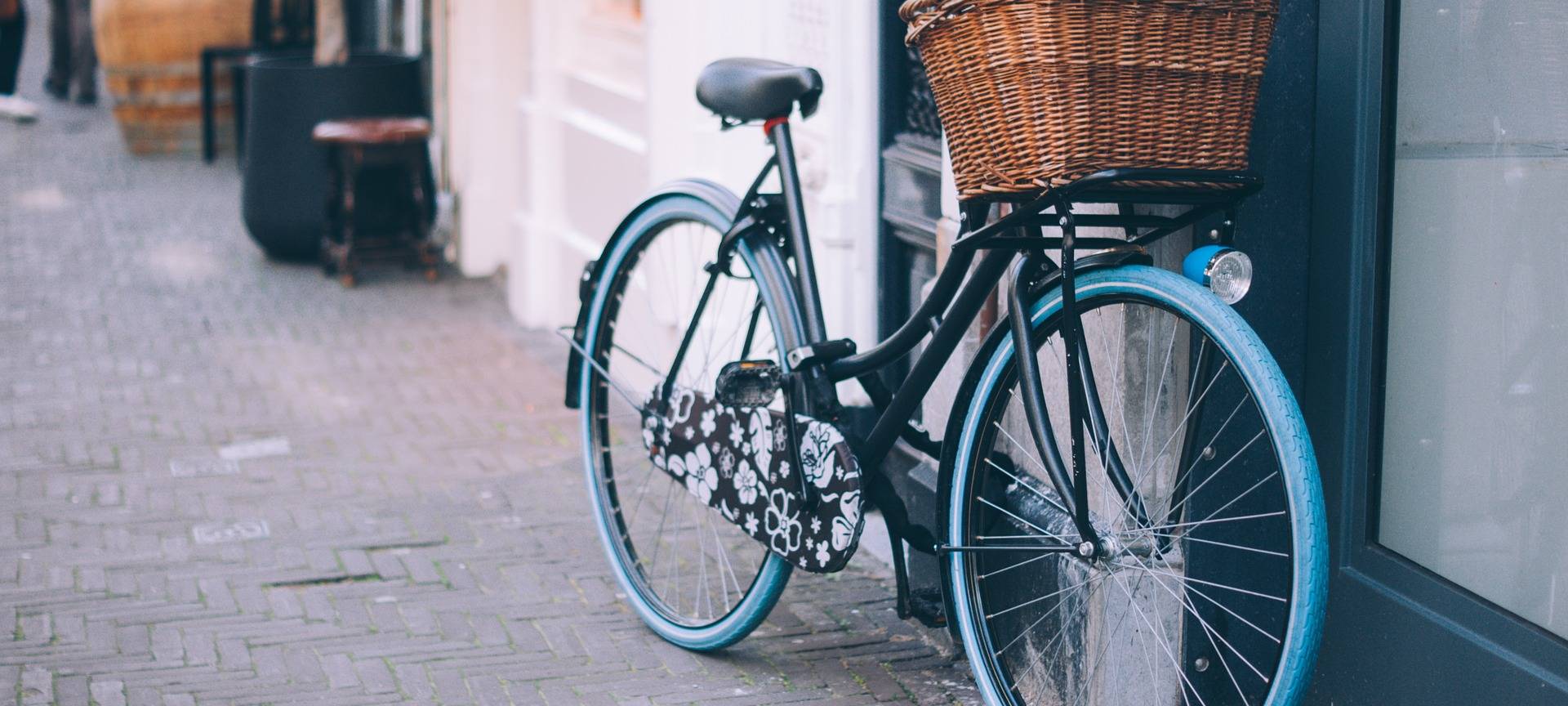 Ein Fahrrad mit blauen Reifen und einem braunen Körbchen.