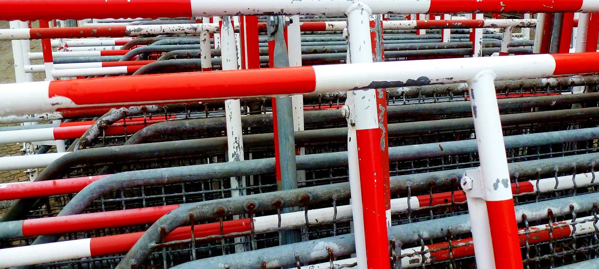 Gestapelte rot-weiße Absperrgitter.