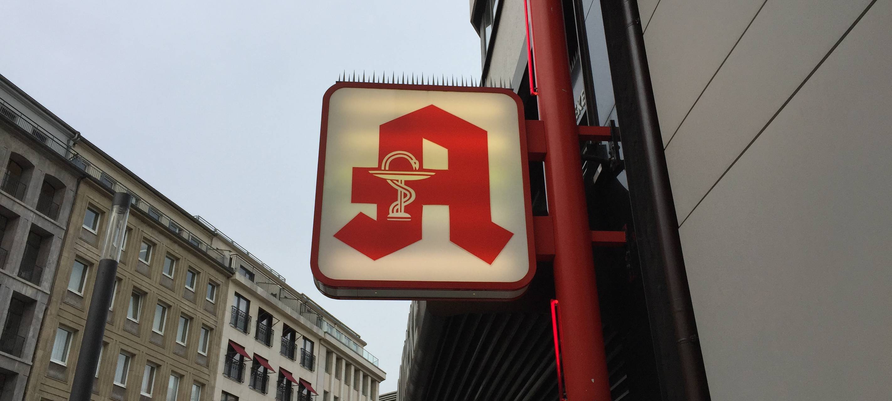 Ein Apothekenschild macht Werbung für eine Apotheke am Schadowplatz.