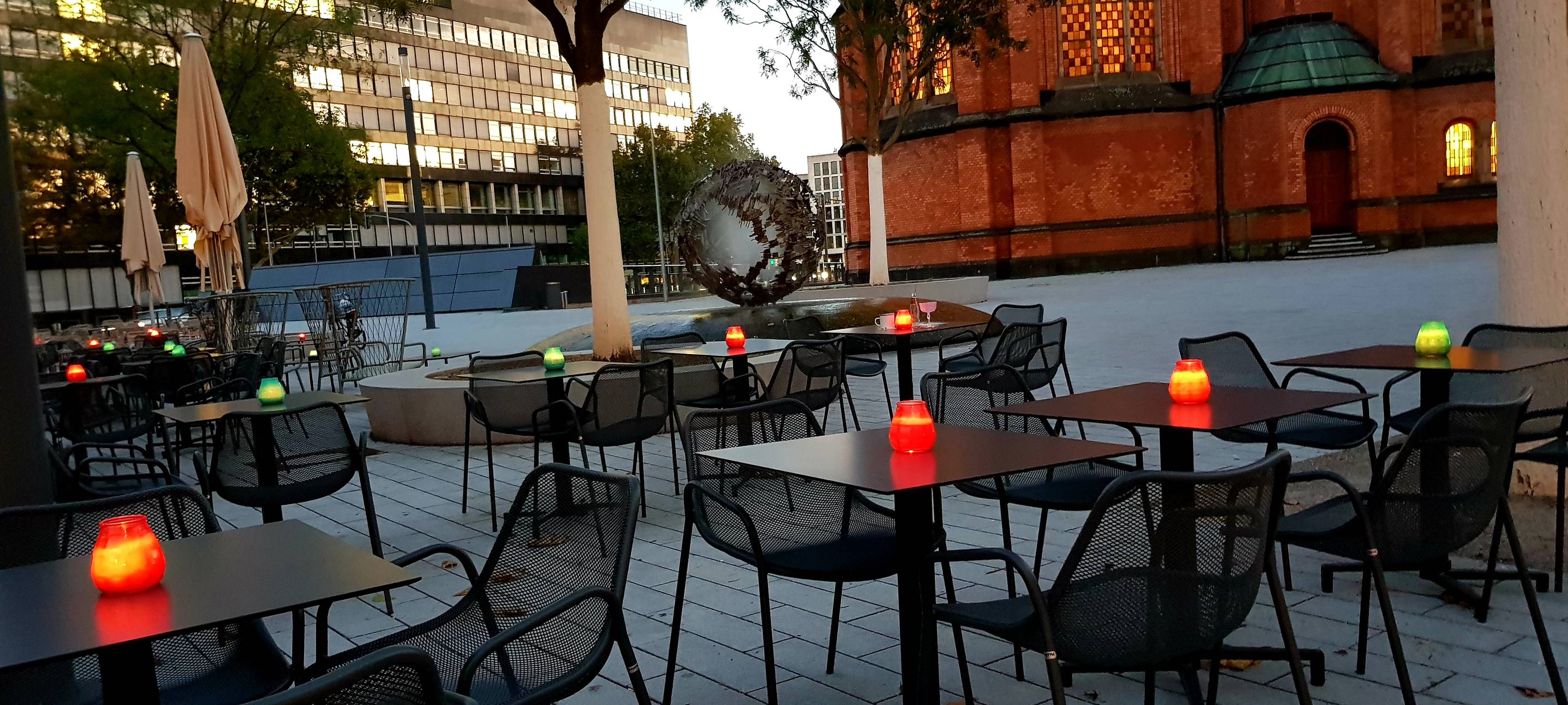 Außengastronomie im Umfeld der Schadow-Arkaden. Im Hintergrund ist die Johanneskirche zu erkennen.