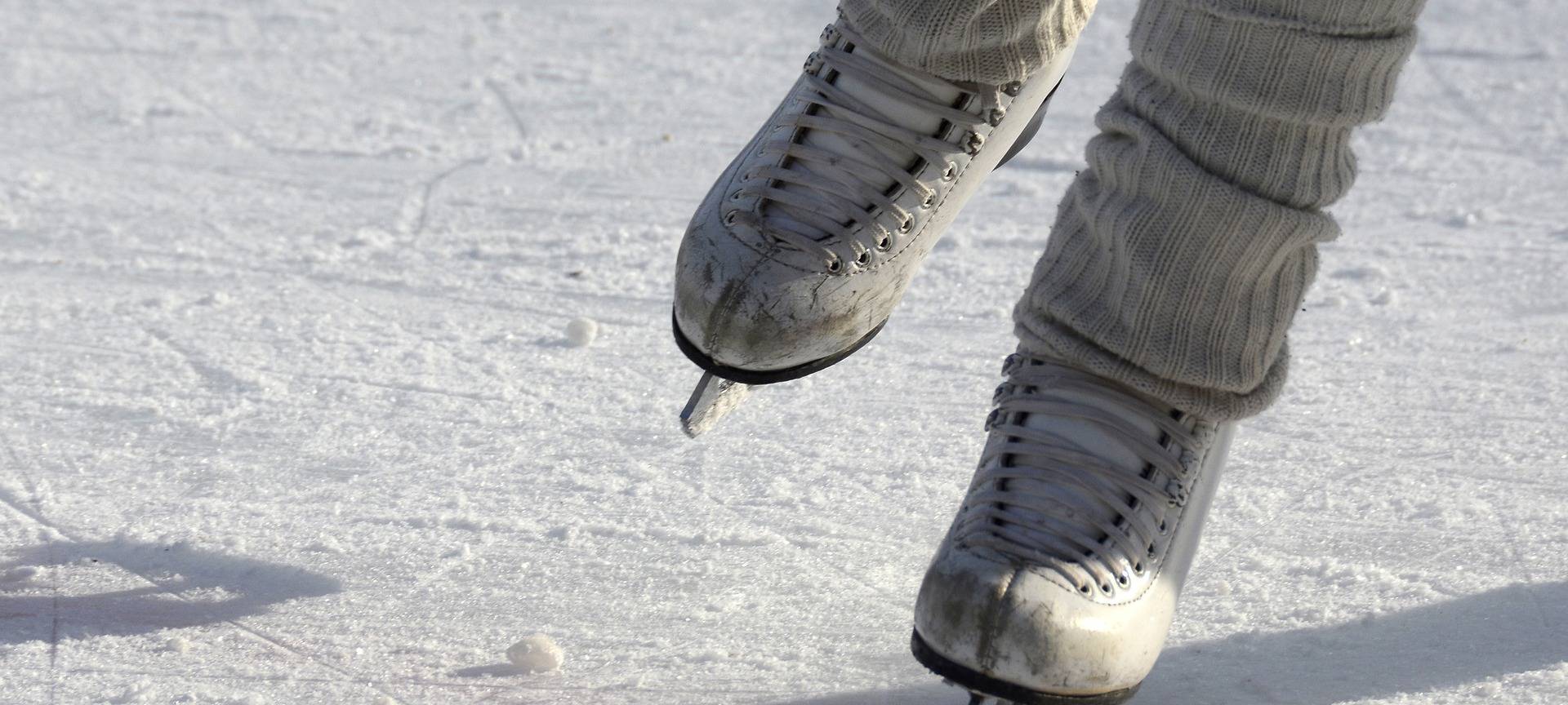 Eine Frau läuft mit ihren Eiskunstlaufschlittschuhen auf einer Eisfläche.