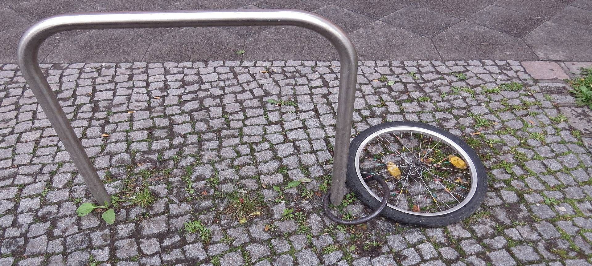 Ein einsames Rad als Rest eines ganzen Fahrrades an einem Fahrradbügel.