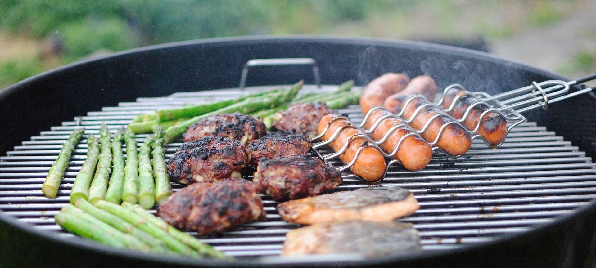 Ein Grill mit Fleisch, Fisch und Gemüse