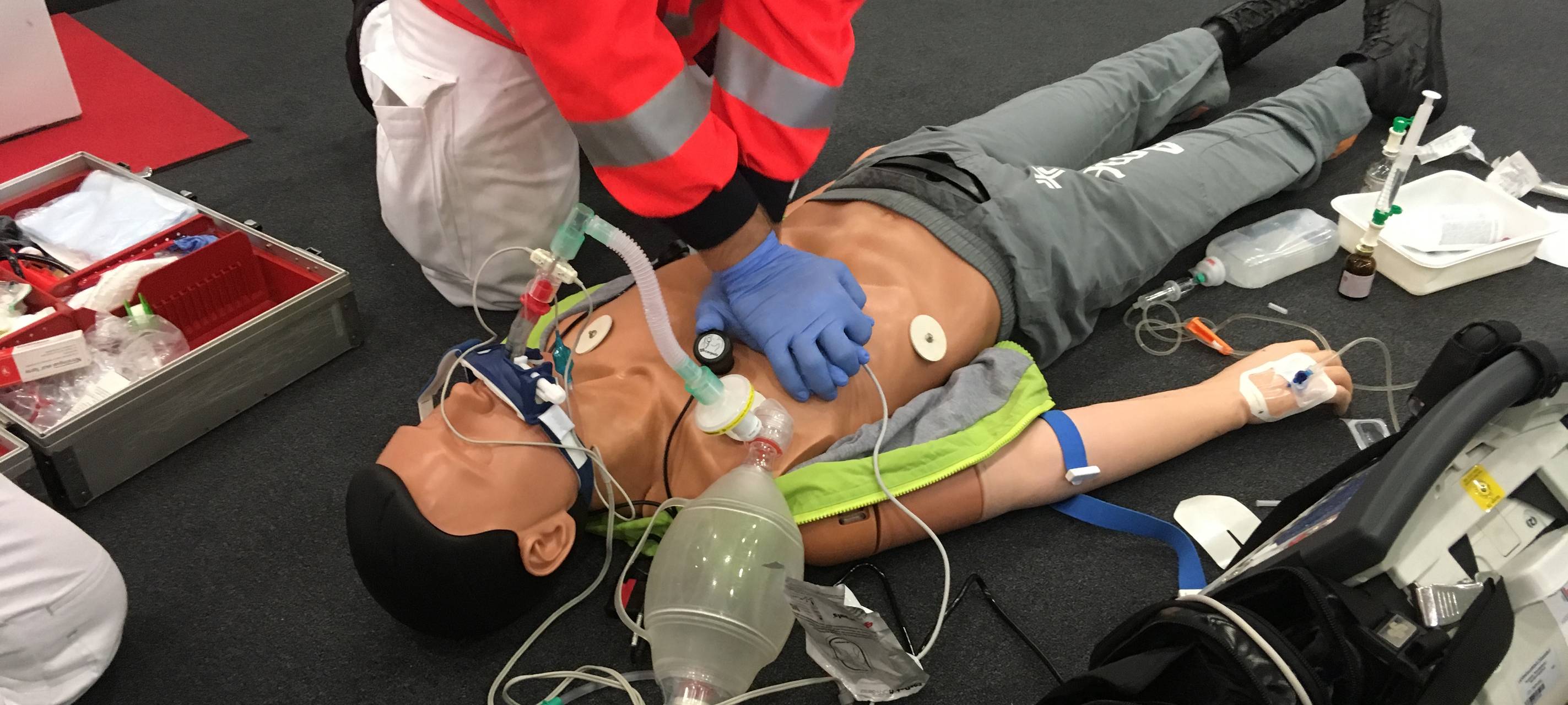 Ein Sanitäter zeigt an einer Puppe, wie man richtig reanimiert.