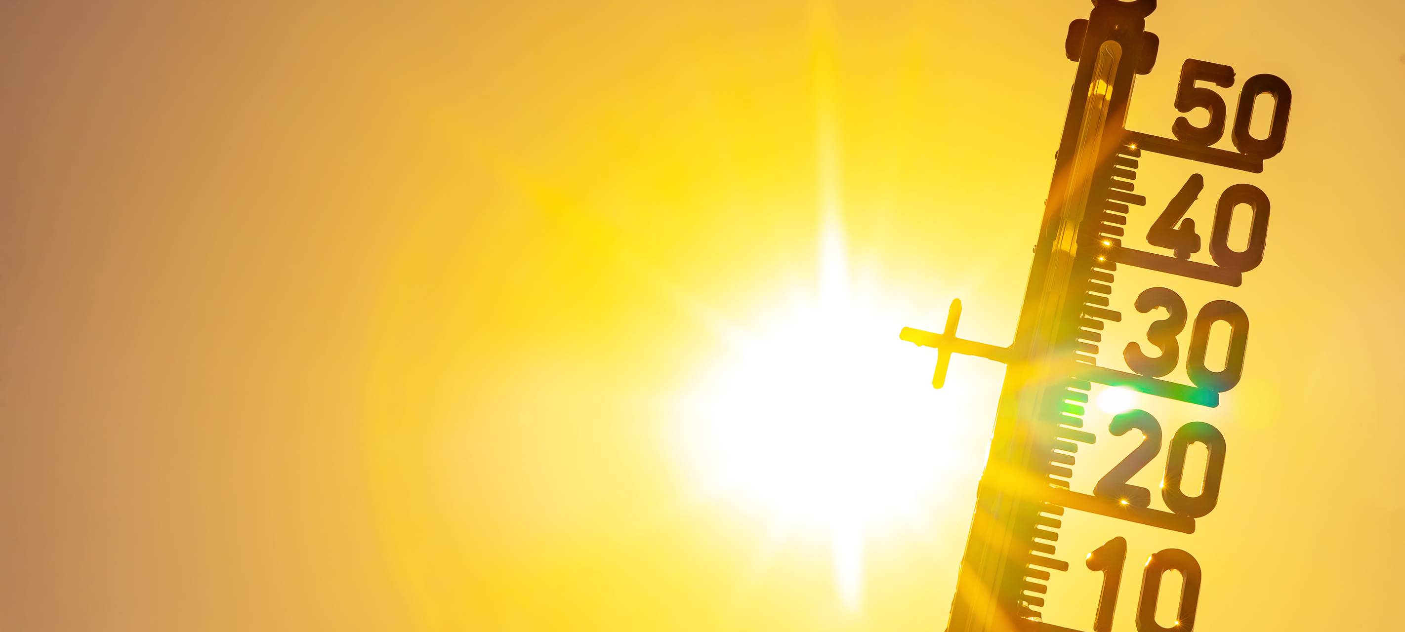 Heißes Wetter – Hitzewelle / Sommerhitze Hintergrund – Thermometer, gelb-oranger Himmel und Sonnenstrahlen