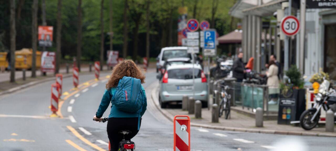 Eine Fahrradfahrerin fährt durch eine deutsche Innenstadt. Sie erhält dabei freie Fahrt, da sie eine eigene Spur bekommt.