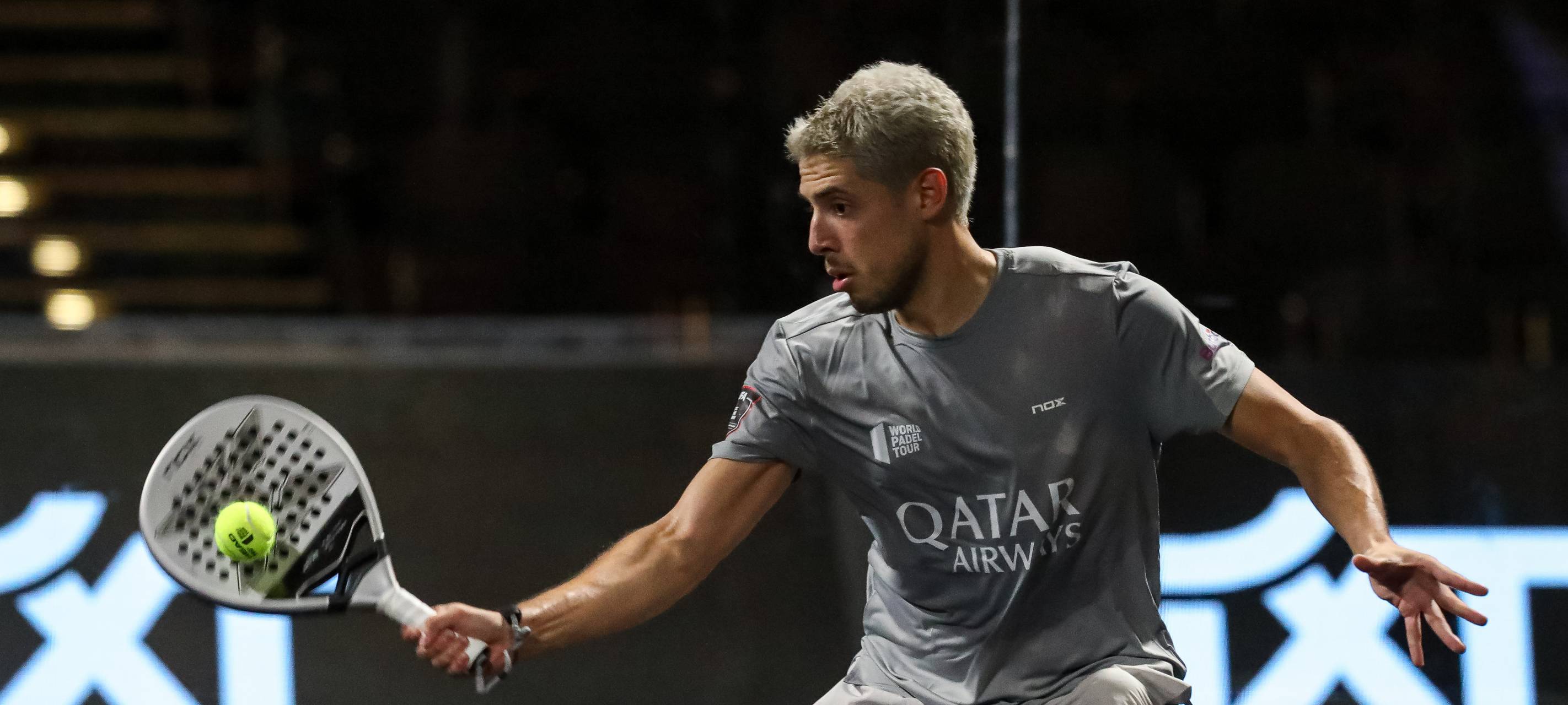 Ein Padel-Spieler trifft den Ball mit seinem Schläger.