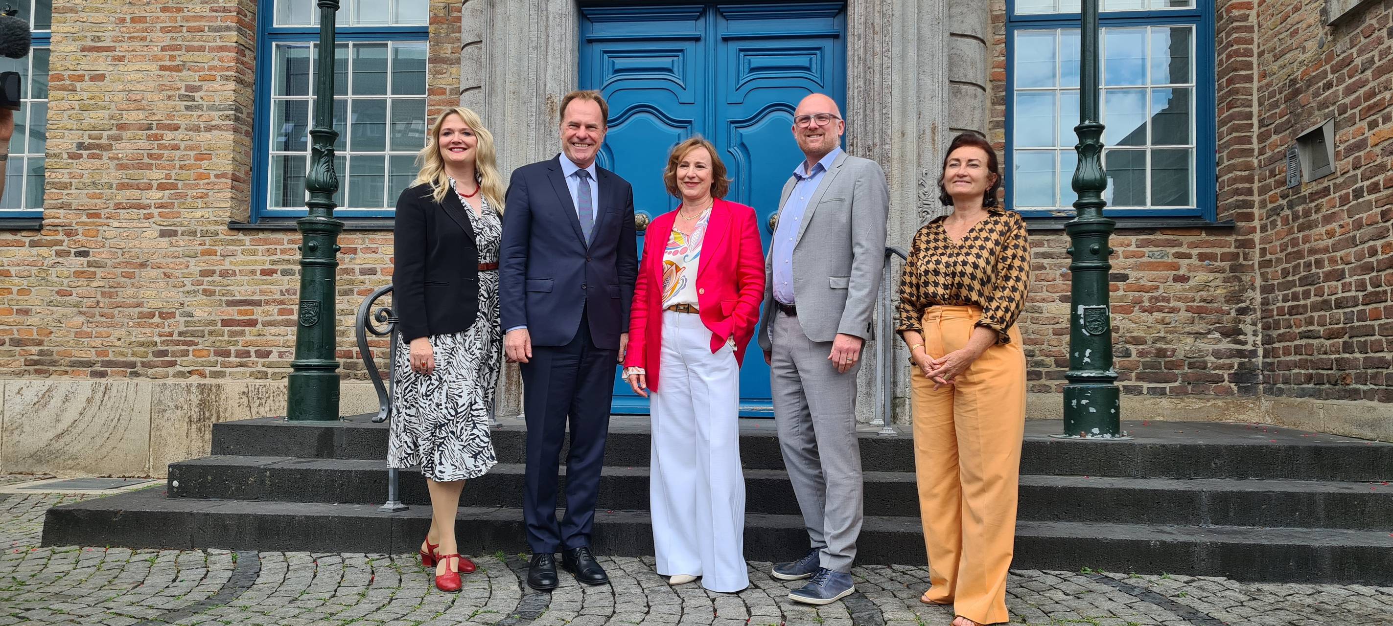 Fünf Menschen stehen vor der Eingangstür zum Rathaus, darunter Oberbürgermeister Keller und Ina Karr, Intendantin der Oper.