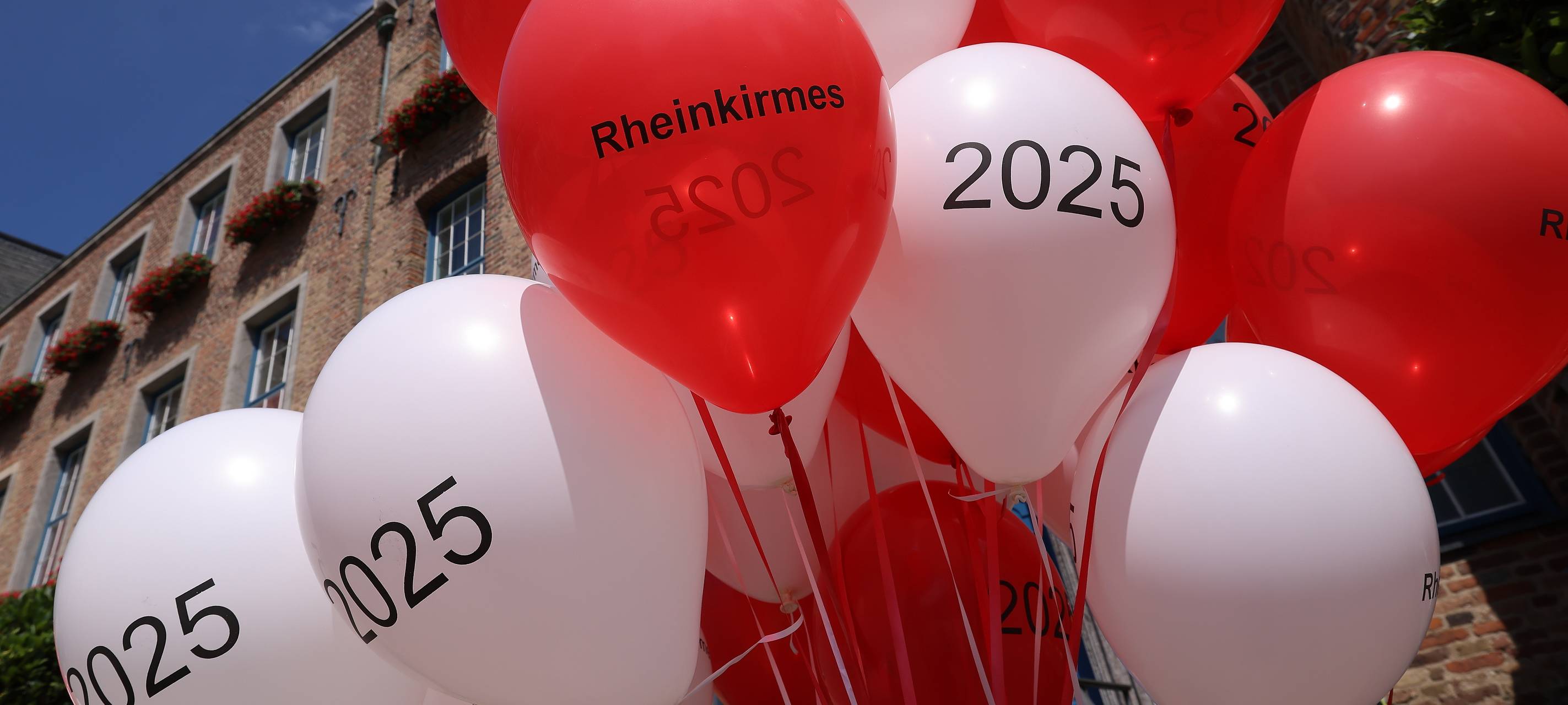 Rot-weiße Luftballons stimmten beim Medientermin auf die Rheinkirmes 2025 ein.