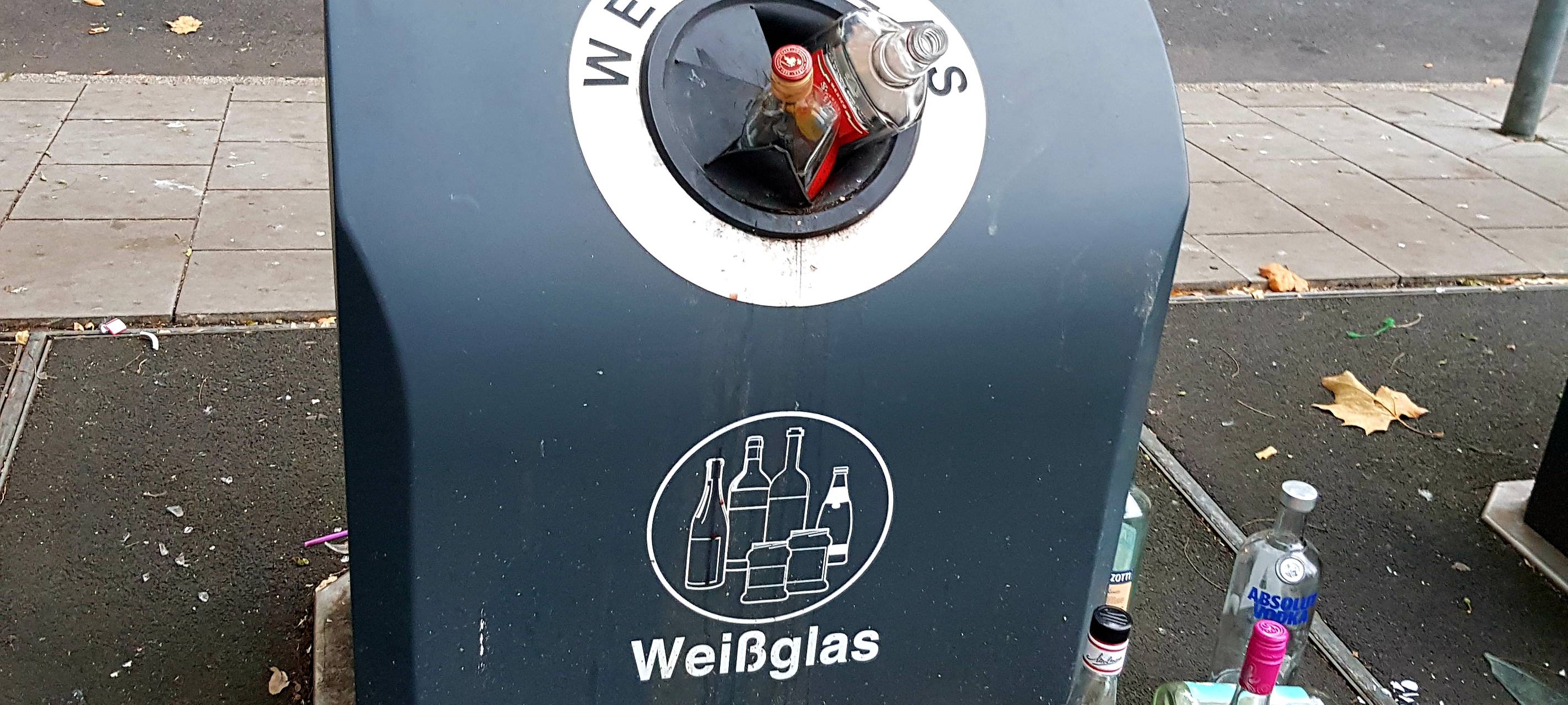 Glasmüll vor unterirdischen Glas-Containern.