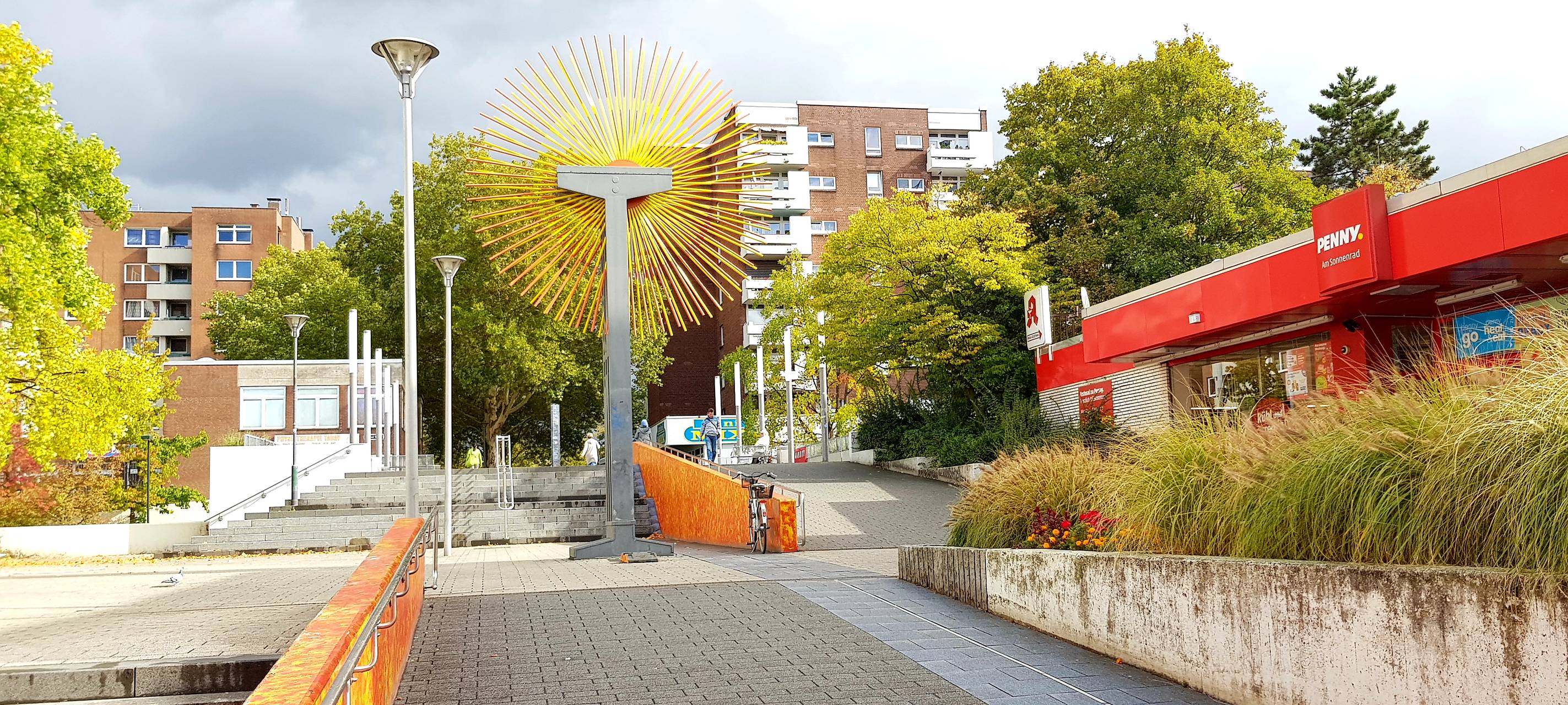 Öffentlicher Platz in Garath mit Sonnenrad in der Mitte.