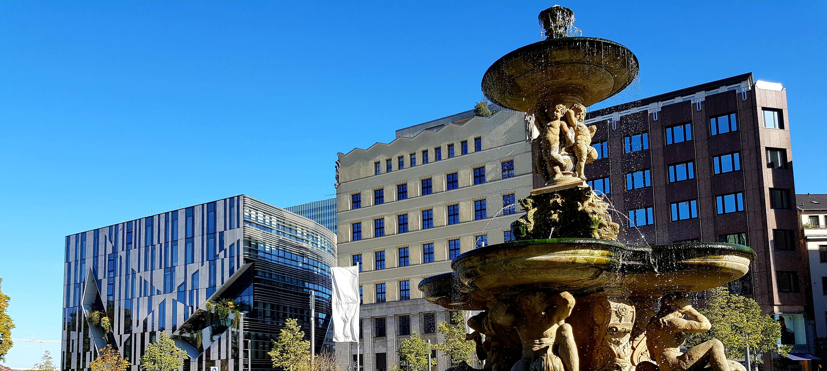 Der Brunnen am Corneeliusplatz an der Königsallee im Sonnenlicht.