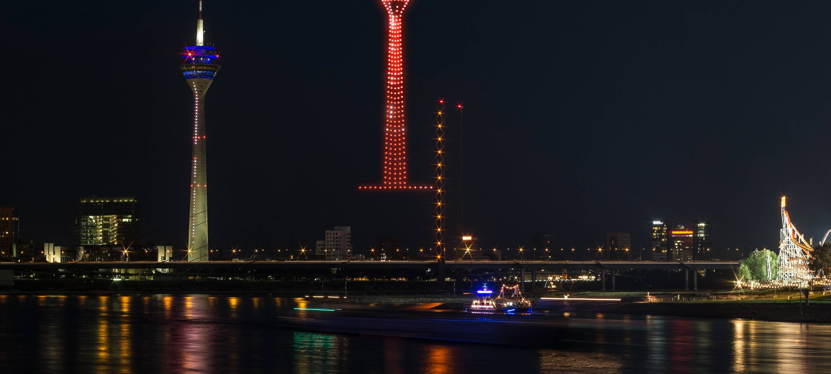 Eine Visualiesierung der Drohnenshow zur Rheinkirmes. Drohnen malen den Rheinturm in den Himmel.
